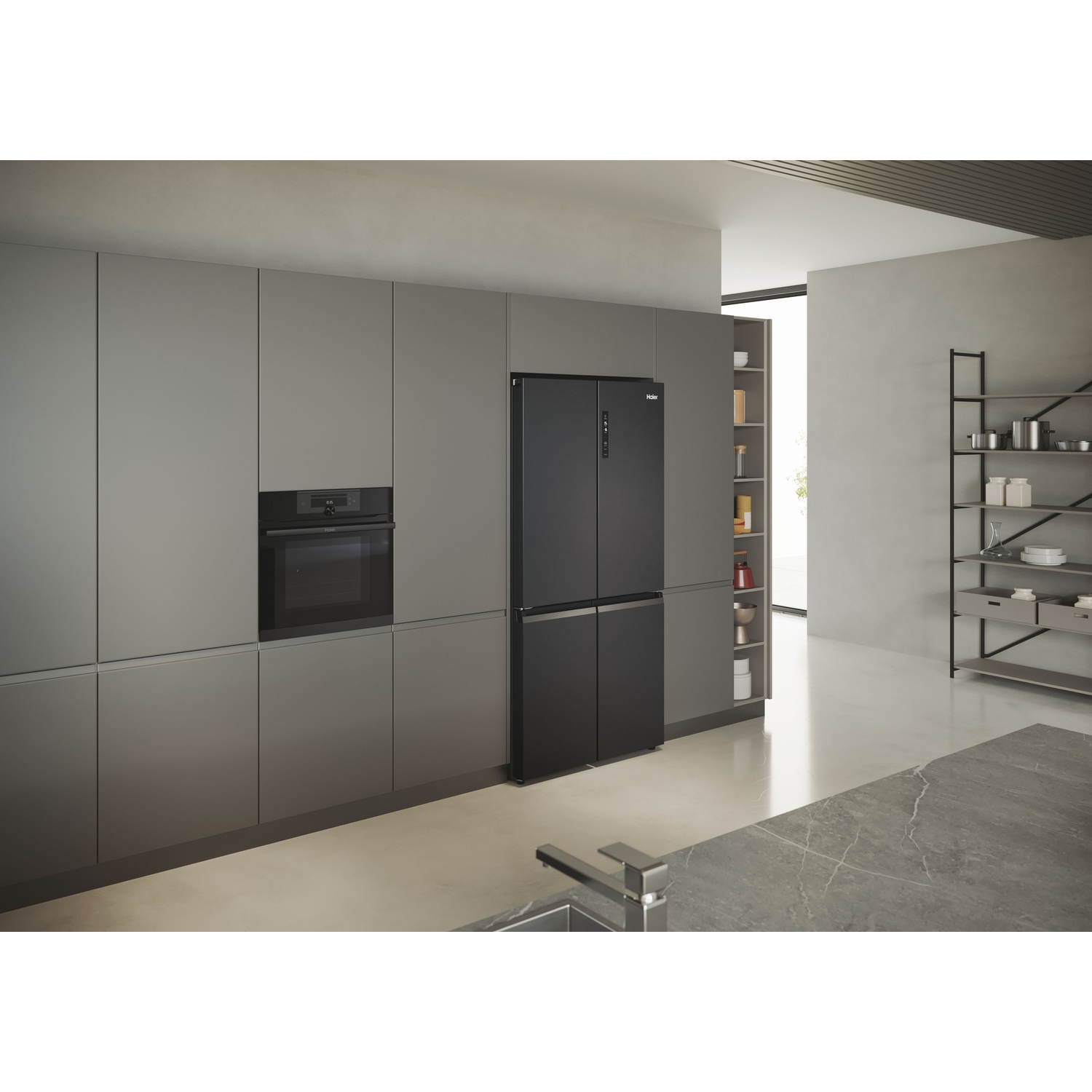 Una cucina moderna con frigorifero, forno e armadi neri. Sono visibili un lavandino e scaffali con oggetti.