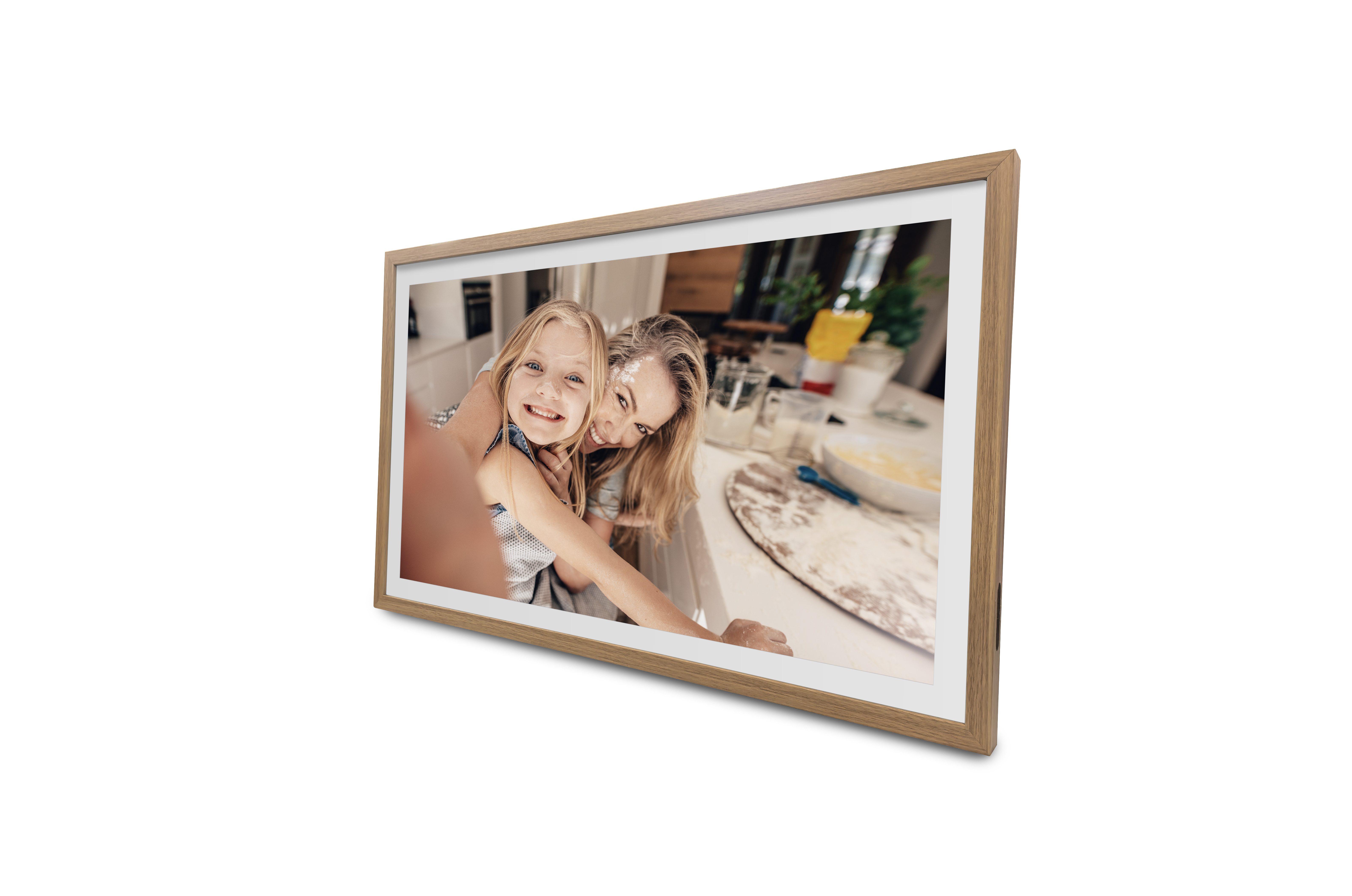 Ein gerahmtes Bild zeigt eine Frau und ein Mädchen, die beim Kochen lächeln. Mehl ist in ihren Gesichtern. Der Hintergrund ist eine Küche.