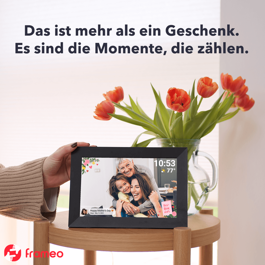 Eine Frau hält einen digitalen Bilderrahmen, der ein Familienfoto zeigt. Tulpen in einer Vase sind im Hintergrund, mit Text darüber.