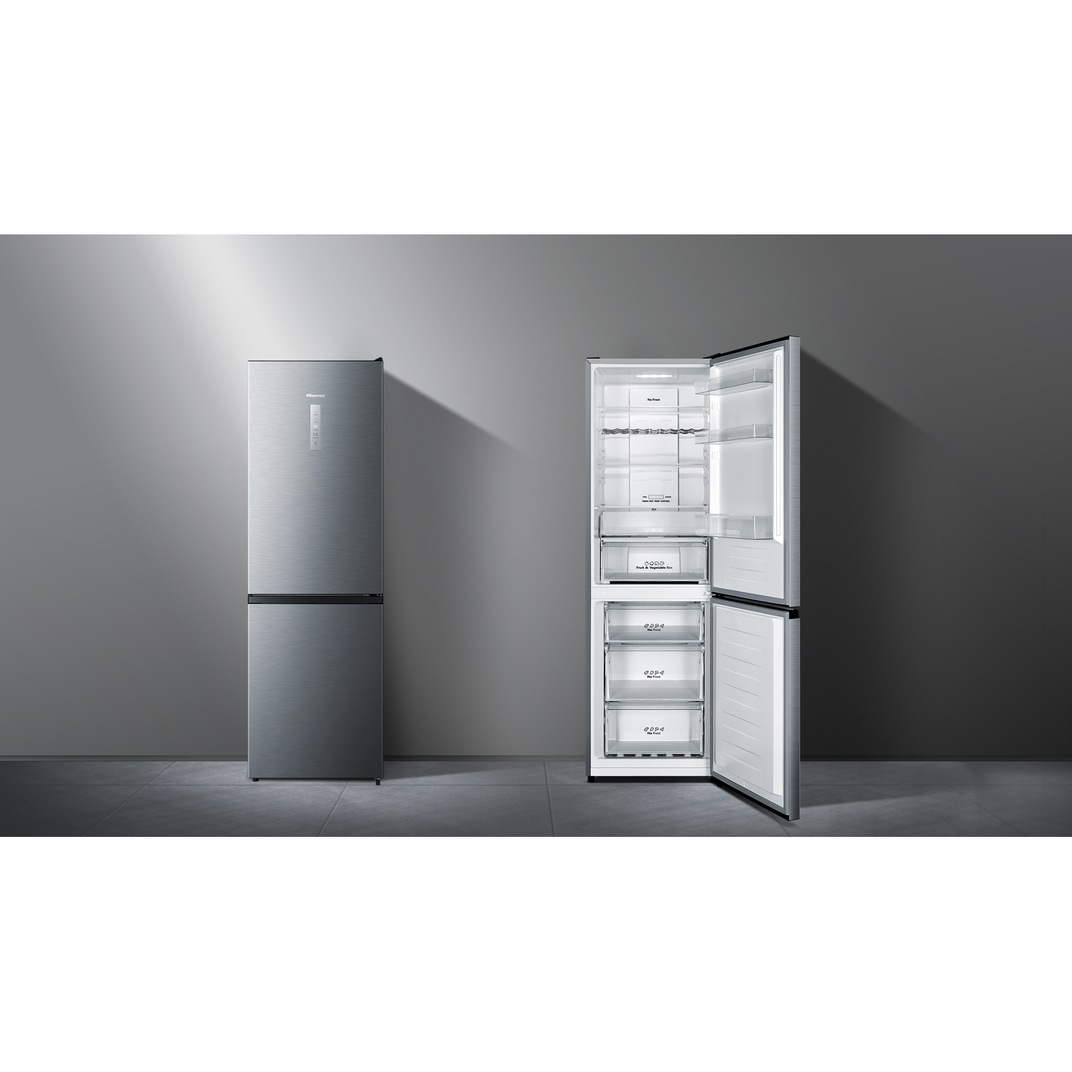 A silver refrigerator, one door closed and the other open. The open door reveals shelves and drawers inside, set against a grey wall.