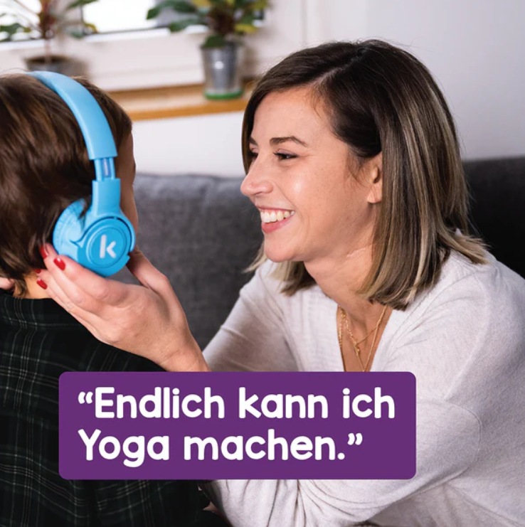 Eine Frau lächelt eine Person mit blauen Kopfhörern an. Der Text lautet: „Endlich kann ich Yoga machen“.