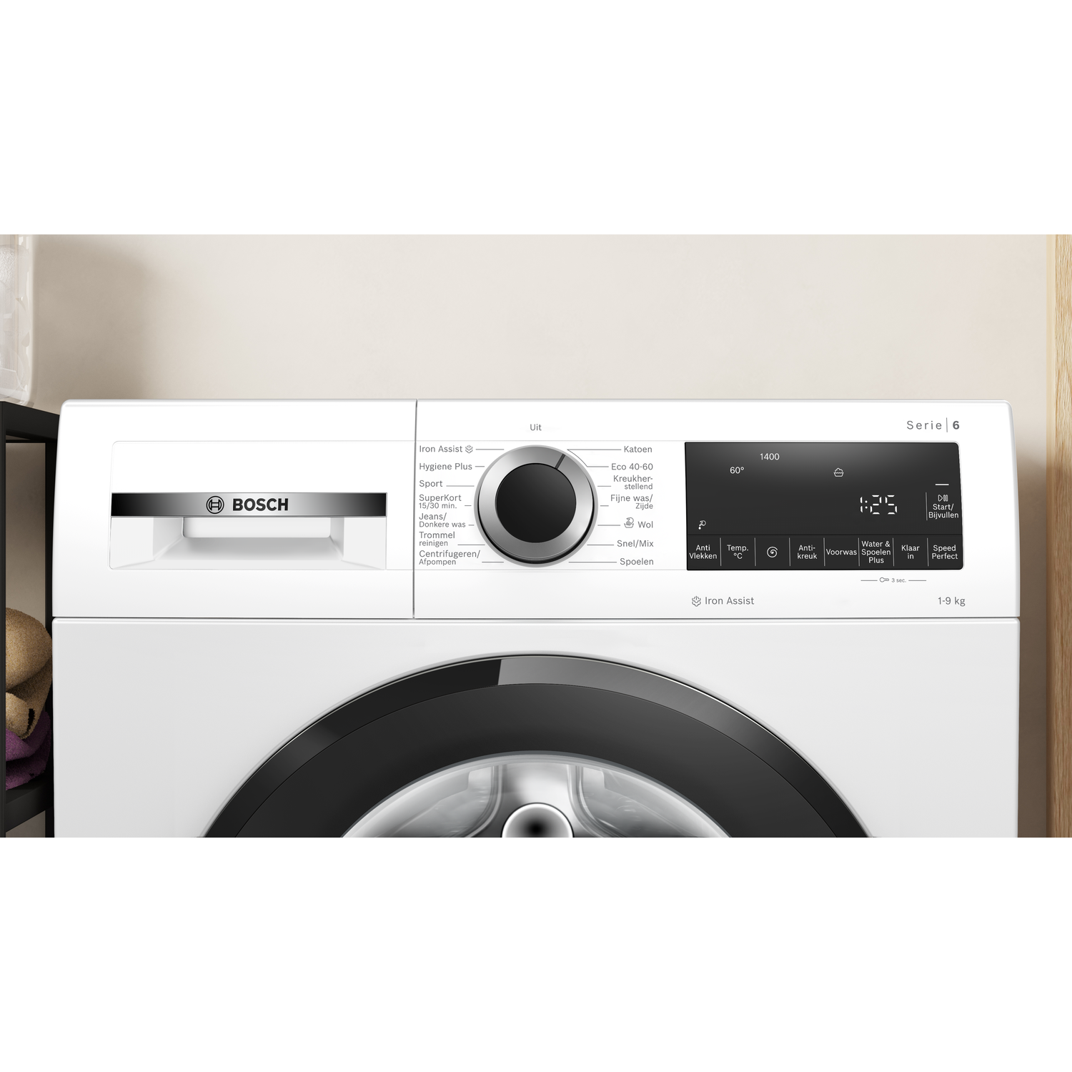 A white Bosch washing machine with a black door. It has a control panel and digital display. The background is a light wall.