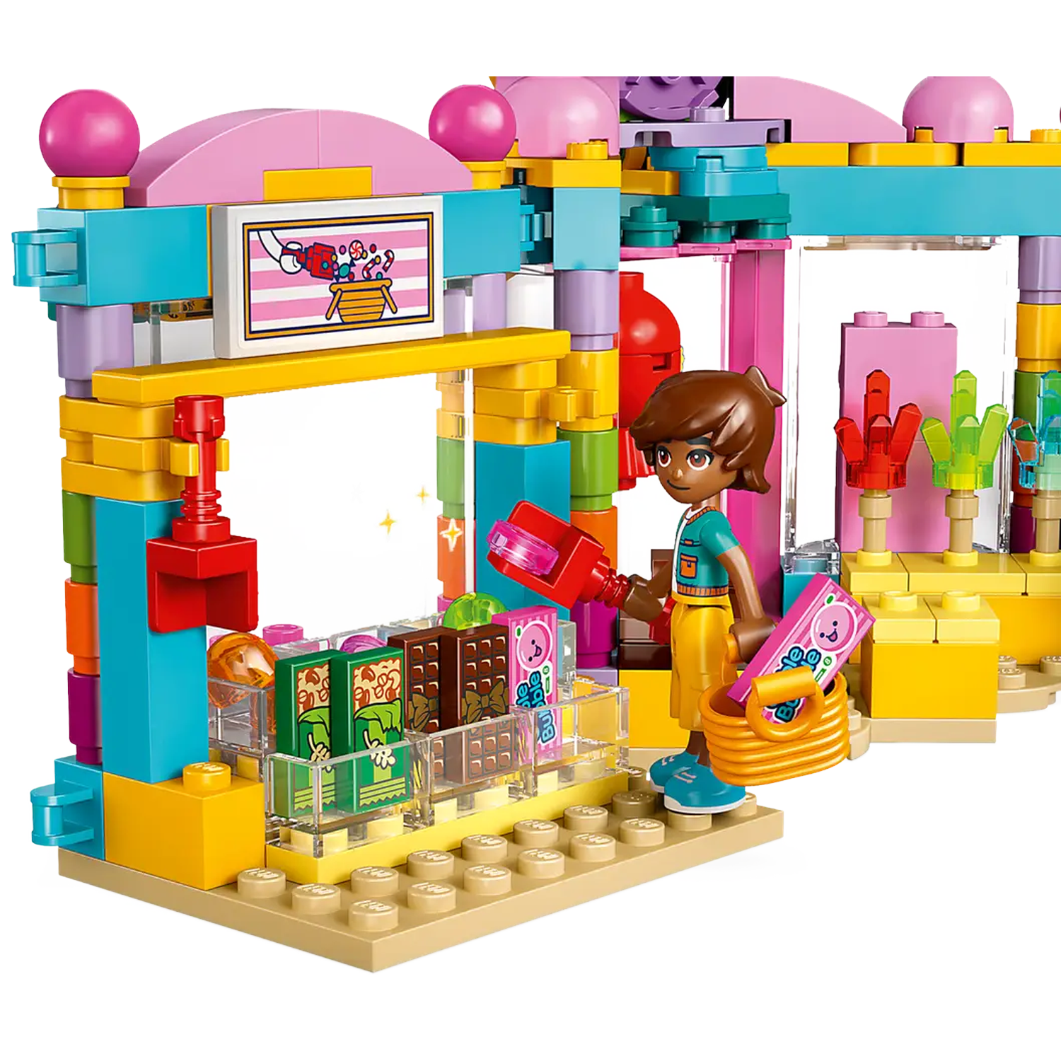 A Lego scene. A figure holds a scoop and a basket. Colorful stalls sell items. Pink and blue structures are present.