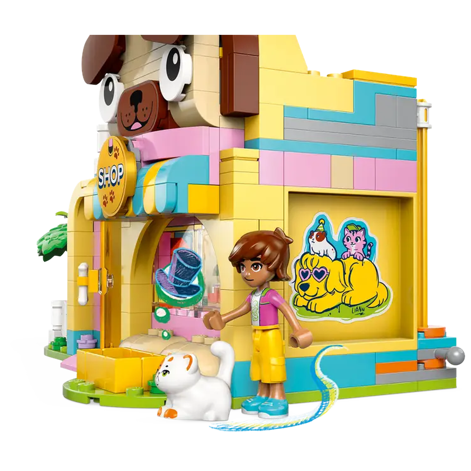 A Lego pet shop with a dog facade. A girl figure stands near a white cat. Colorful building, yellow, pink, and blue. 