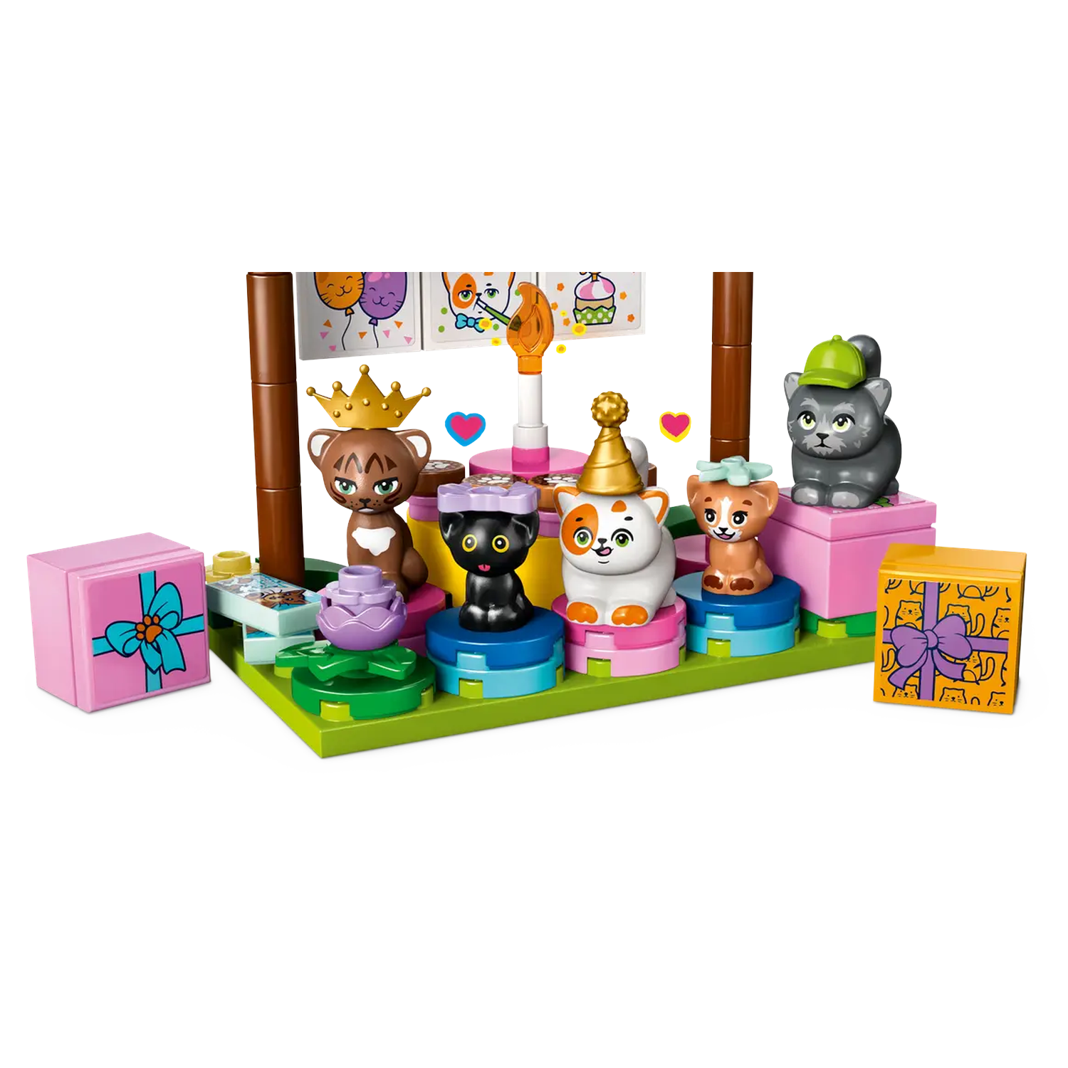 A birthday scene with cat figures. There are balloons, a cake, and gifts. Cats are wearing hats and crowns. Pink and green colors.