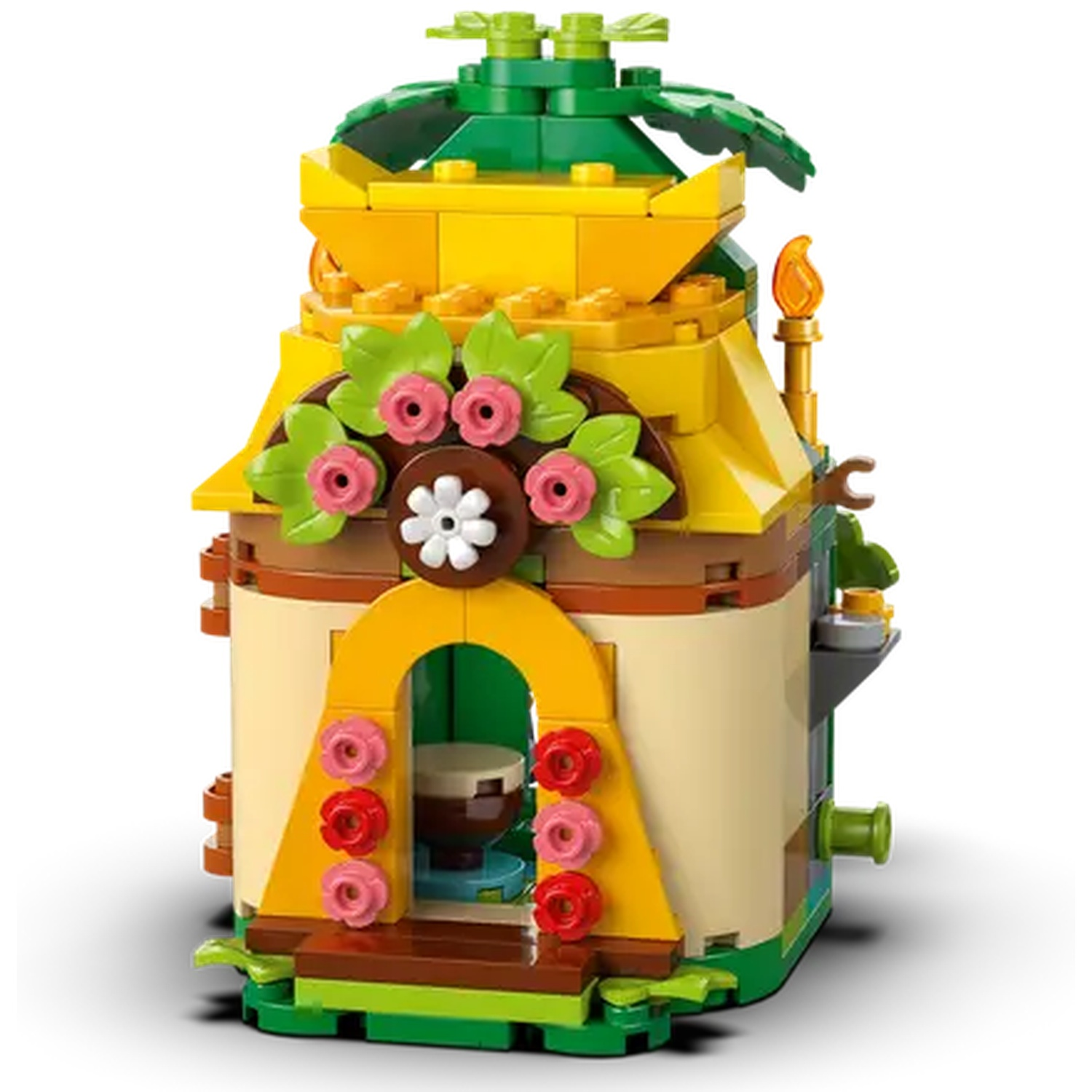 Un bâtiment Lego coloré avec un toit jaune, des feuilles vertes et des fleurs roses et rouges. Il a une entrée en arc et une torche.