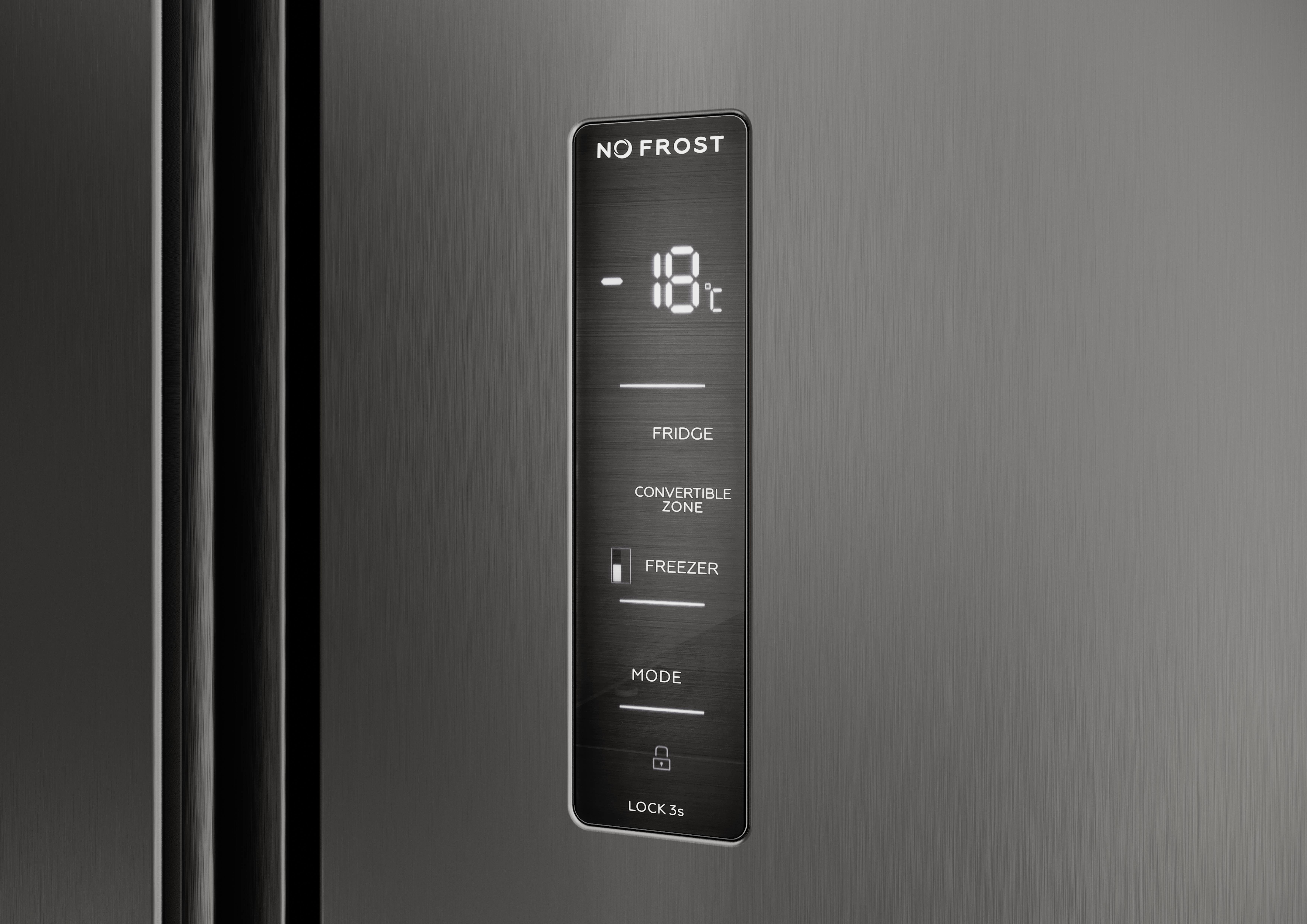 Zbliżenie drzwi lodówki z cyfrowym wyświetlaczem -18°C. Etykiety tekstowe: Lodówka, Strefa konwertowalna, Zamrażarka, Tryb, Blokada.