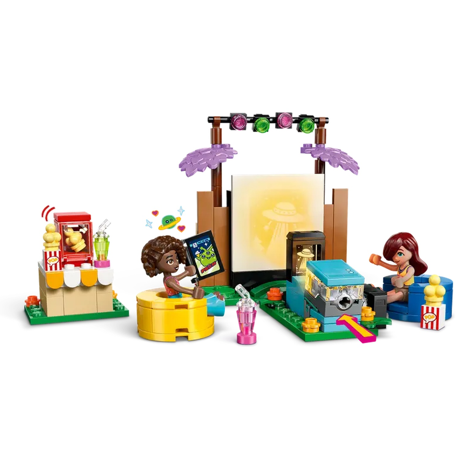 Lego set with figures and structures: popcorn stand, screen with alien, figures watching a screen, and a projector.