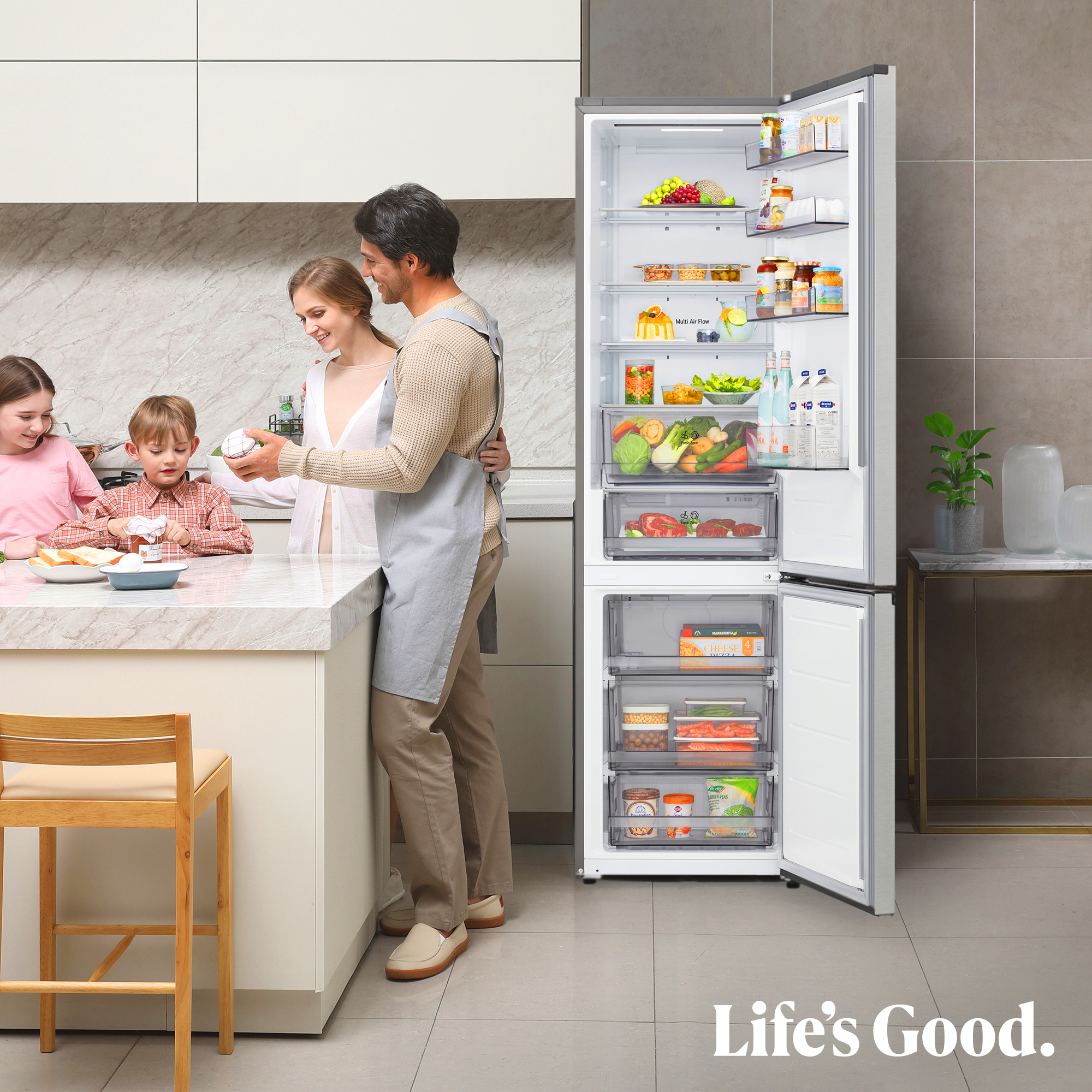 Familia en la cocina cerca de la nevera abierta. Niños preparando comida. Refrigerador lleno de alimentos. Texto: Life's Good.