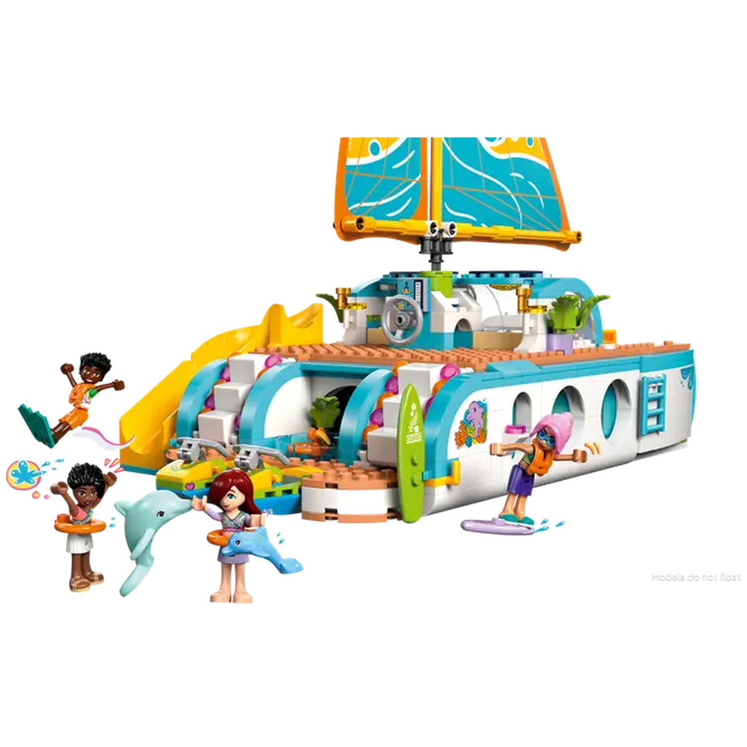 Lego set depicting a boat with figures and a slide. Figures are playing with dolphins and surfing. The boat has a sail.
