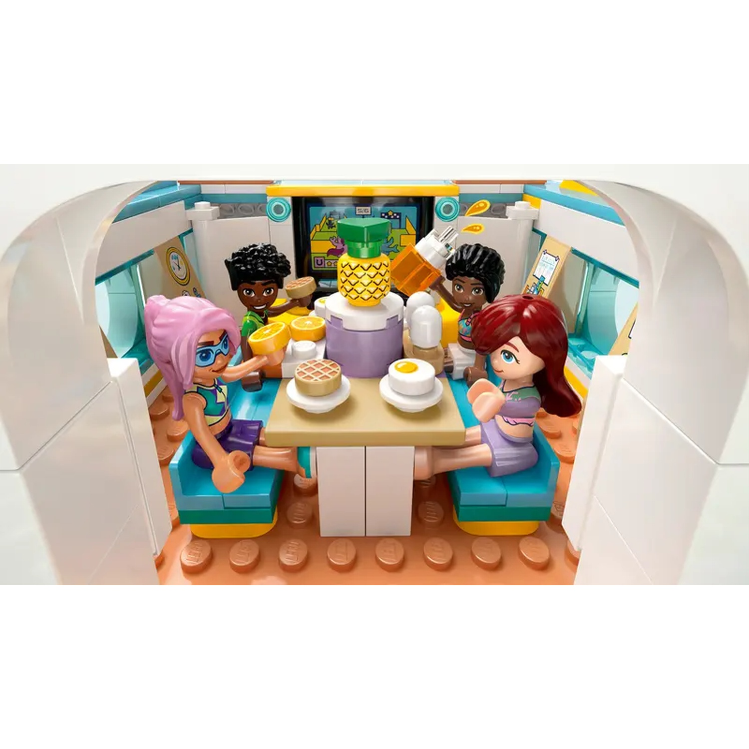 Lego scene with four figures around a table with food. Pineapple, waffles, and eggs are visible. The setting is bright and cheerful.