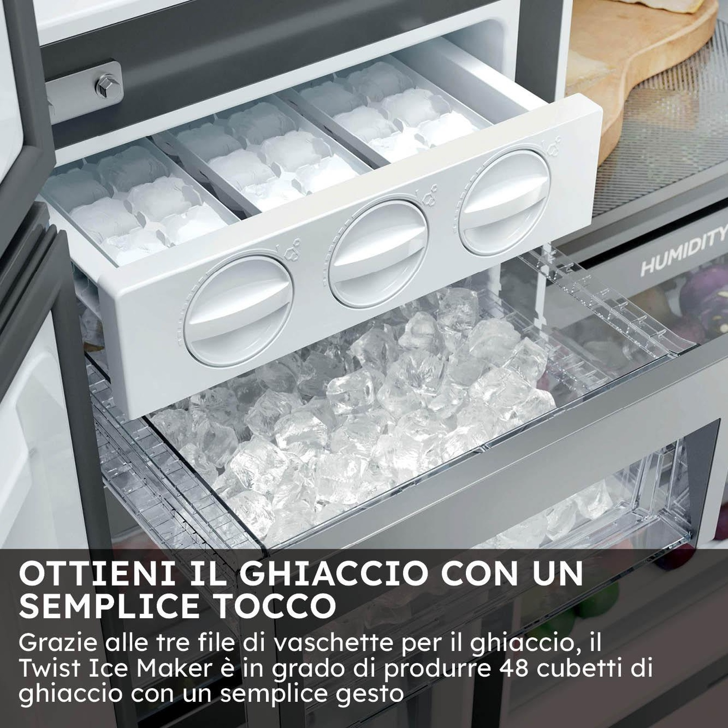 Una fabbricatrice di ghiaccio all'interno di un frigorifero. Tre file di vaschette per il ghiaccio sopra un contenitore pieno di cubetti di ghiaccio. La parola HUMIDITY è visibile.