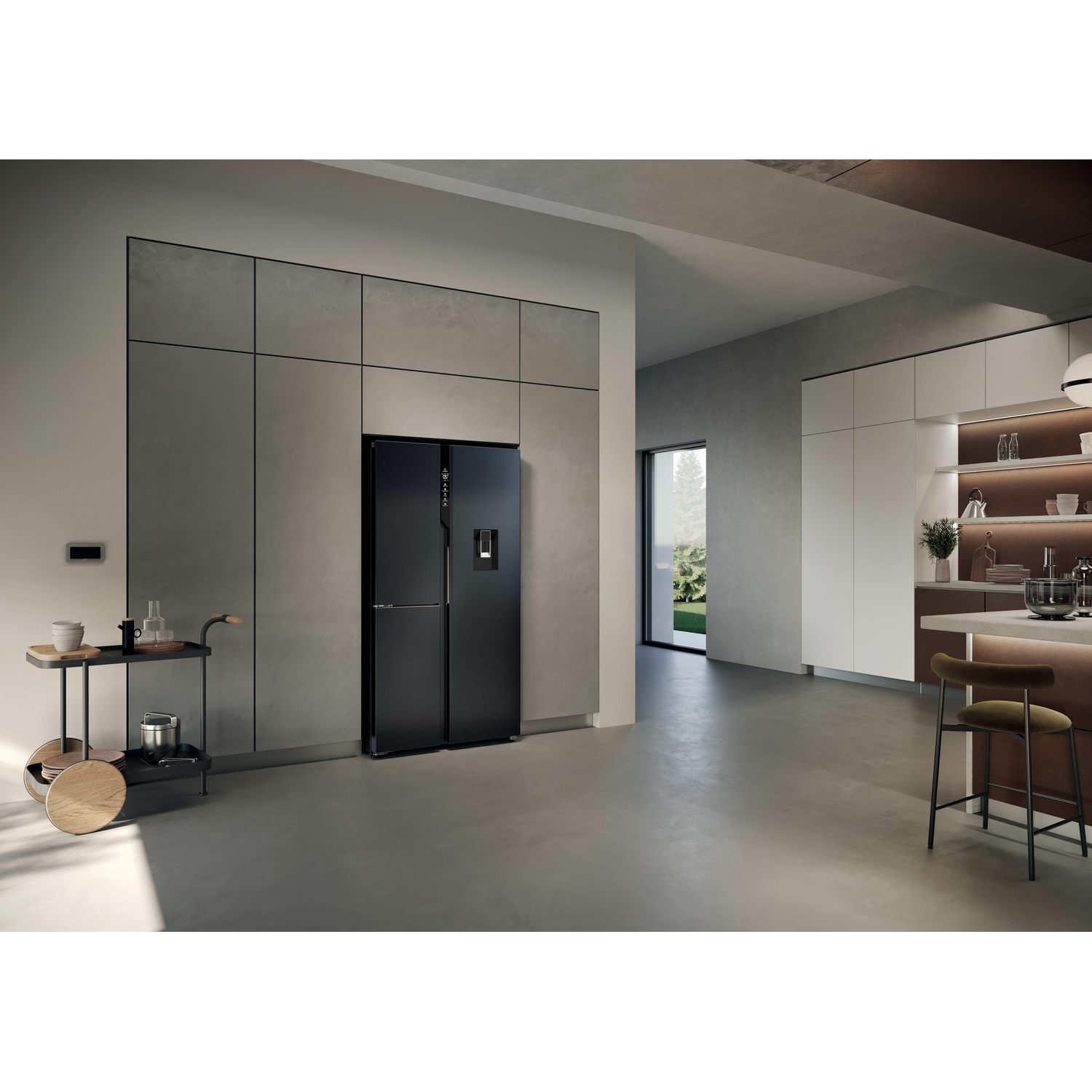 Una cucina moderna con un frigorifero nero. Un carrello di servizio e uno sgabello in primo piano. Luce intensa dalla finestra.