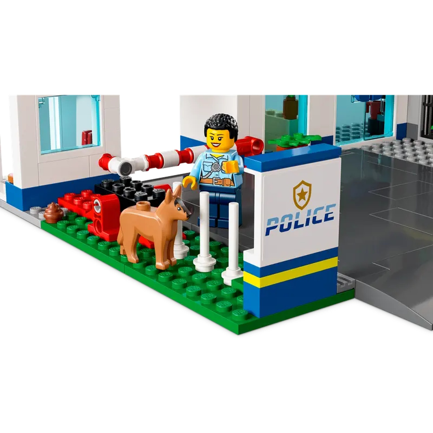 Lego police station with a police officer, a dog, and a sign that says Police. The scene has a barrier and a garage.