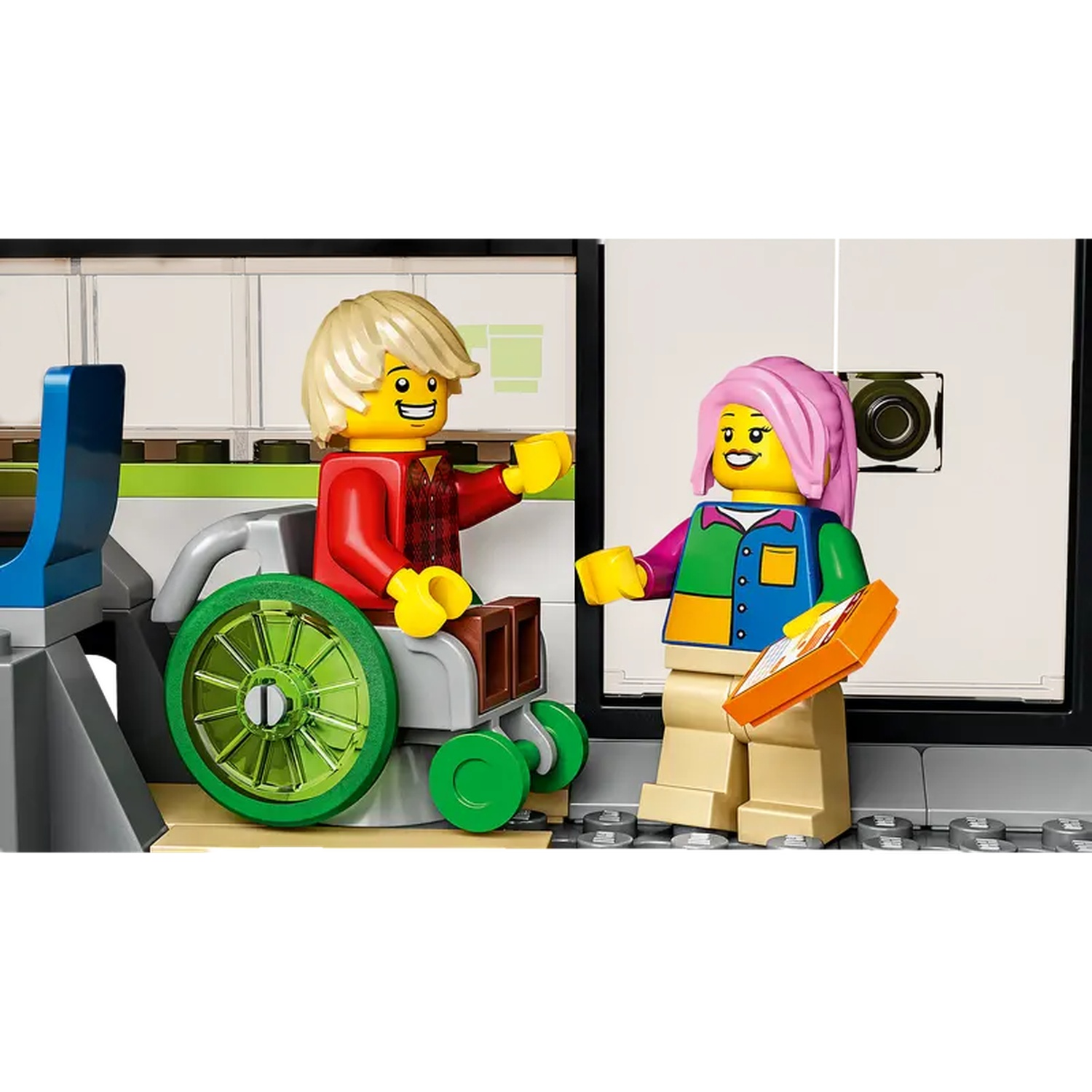 Lego scene: a person in a wheelchair and another with pink hair are interacting. The person with pink hair is holding an orange tablet.