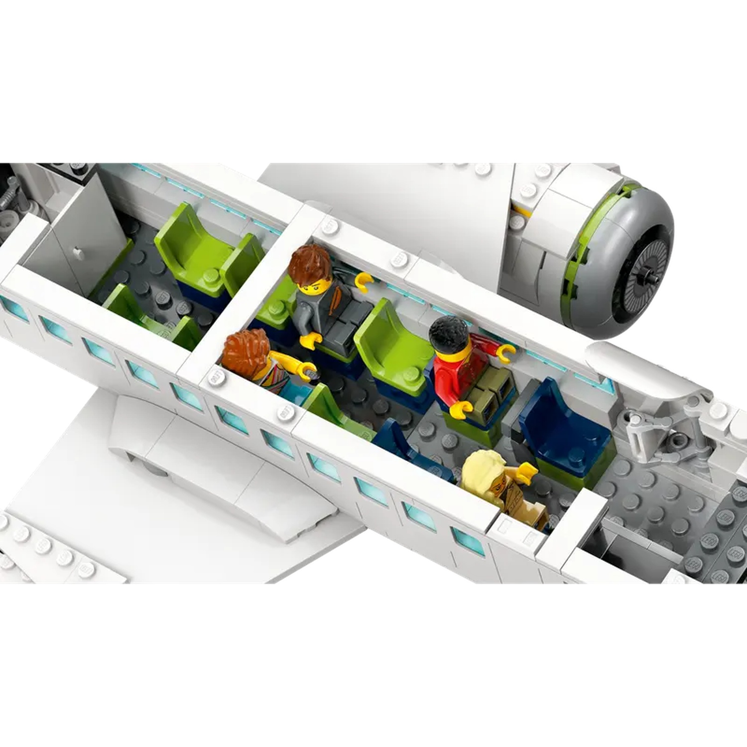 A Lego airplane interior with passengers in seats. The plane is white with green, blue seats, and a gray floor.