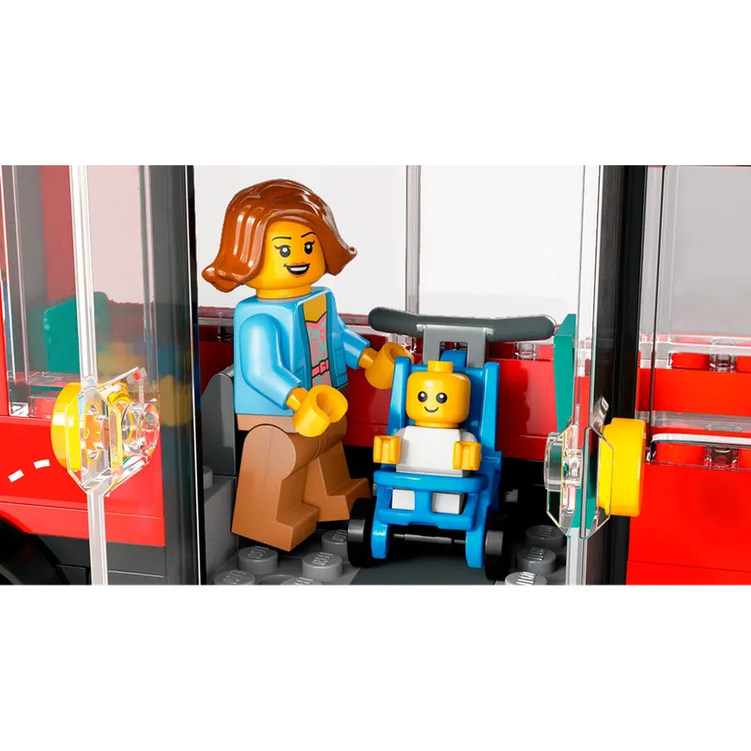 A Lego figure of a woman and a baby in a stroller are inside a red bus. The woman is wearing a blue jacket.
