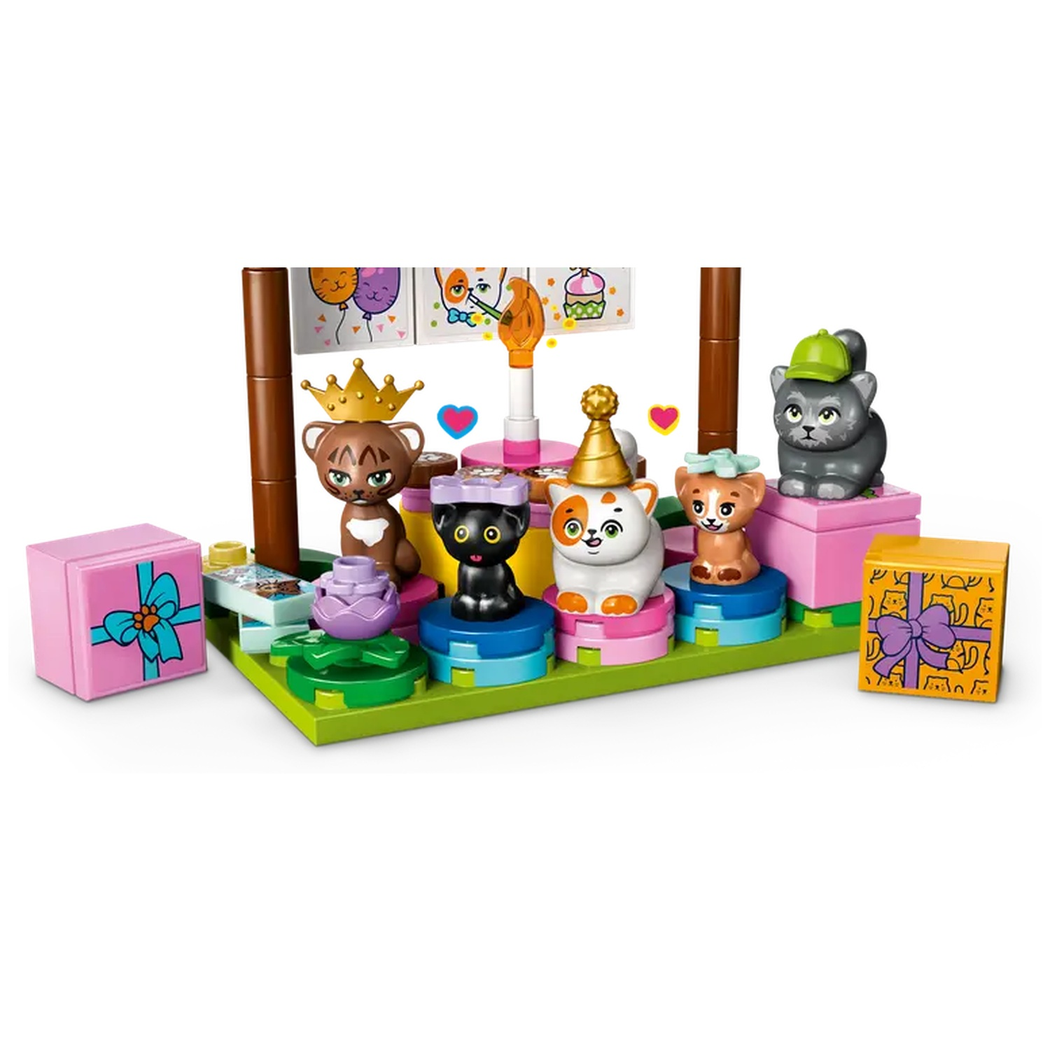 A birthday scene with cat figures. There are gifts, a cake, and decorations. Cats wear hats and crowns.