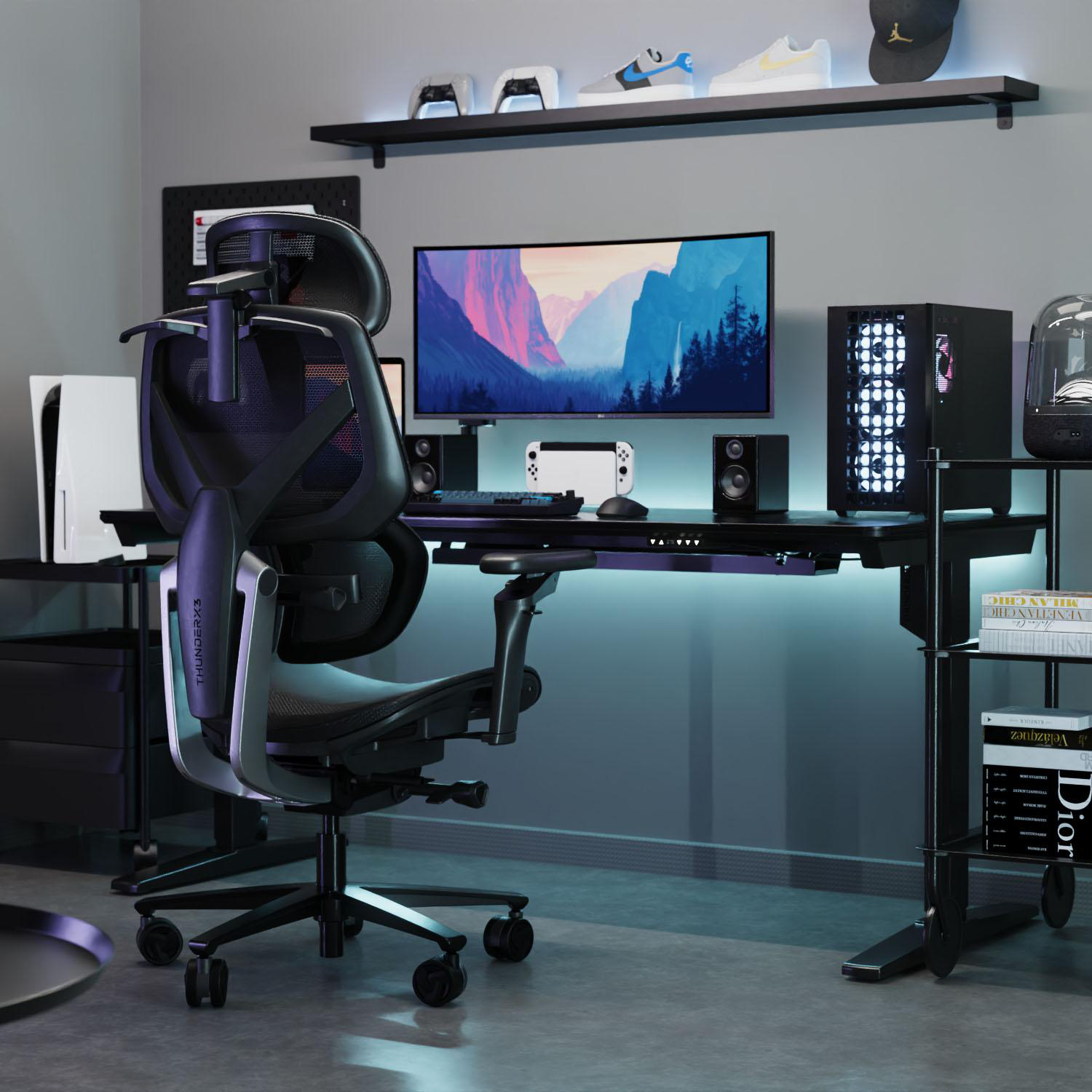 Gaming-Setup mit schwarzem Schreibtisch, Stuhl, PC, Monitor und Zubehör. Ein Regal darüber beherbergt Schuhe und eine Mütze.