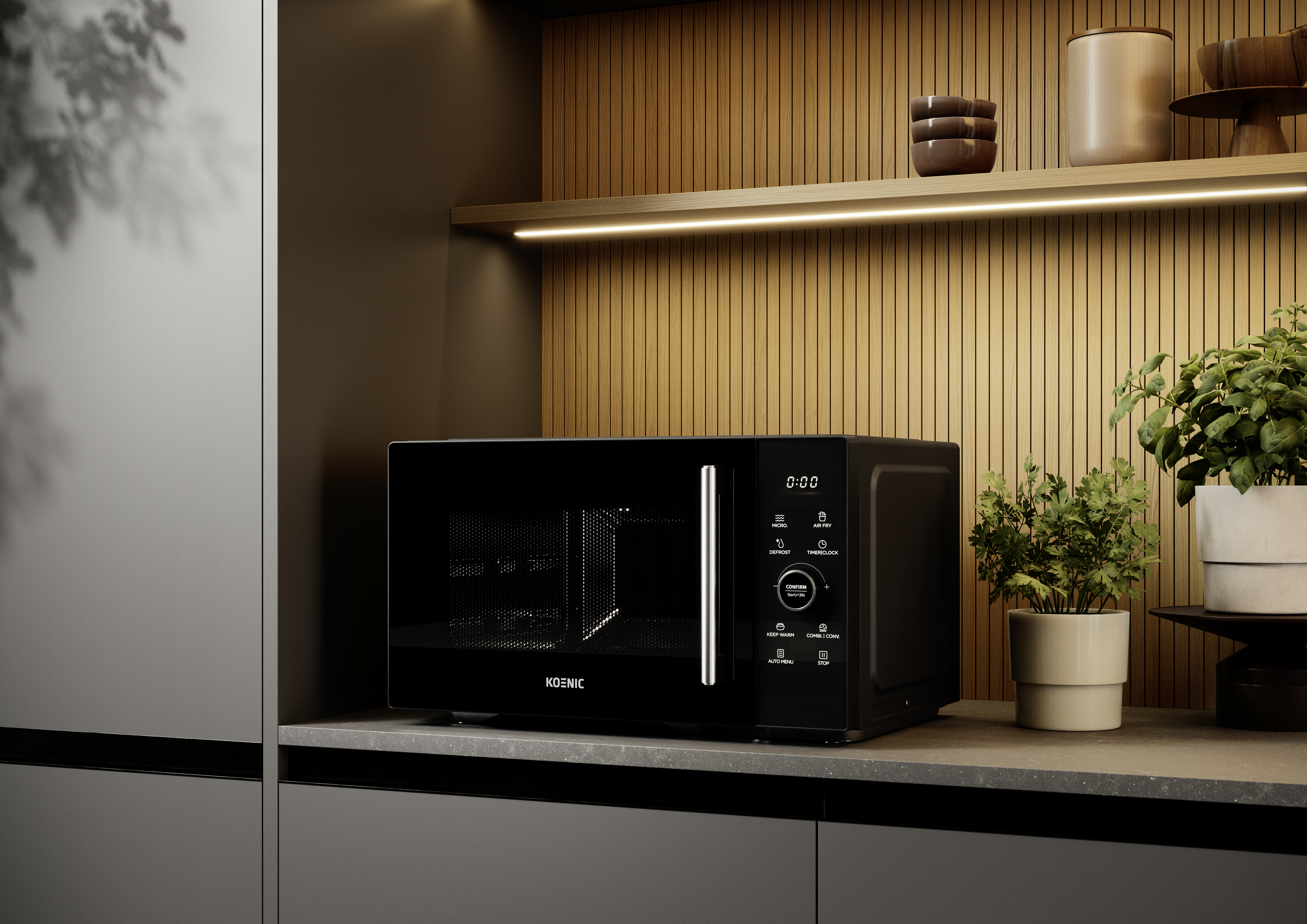 Czarna kuchenka mikrofalowa stoi na blacie w kuchni. W pobliżu na półce stoi roślina i elementy dekoracyjne.