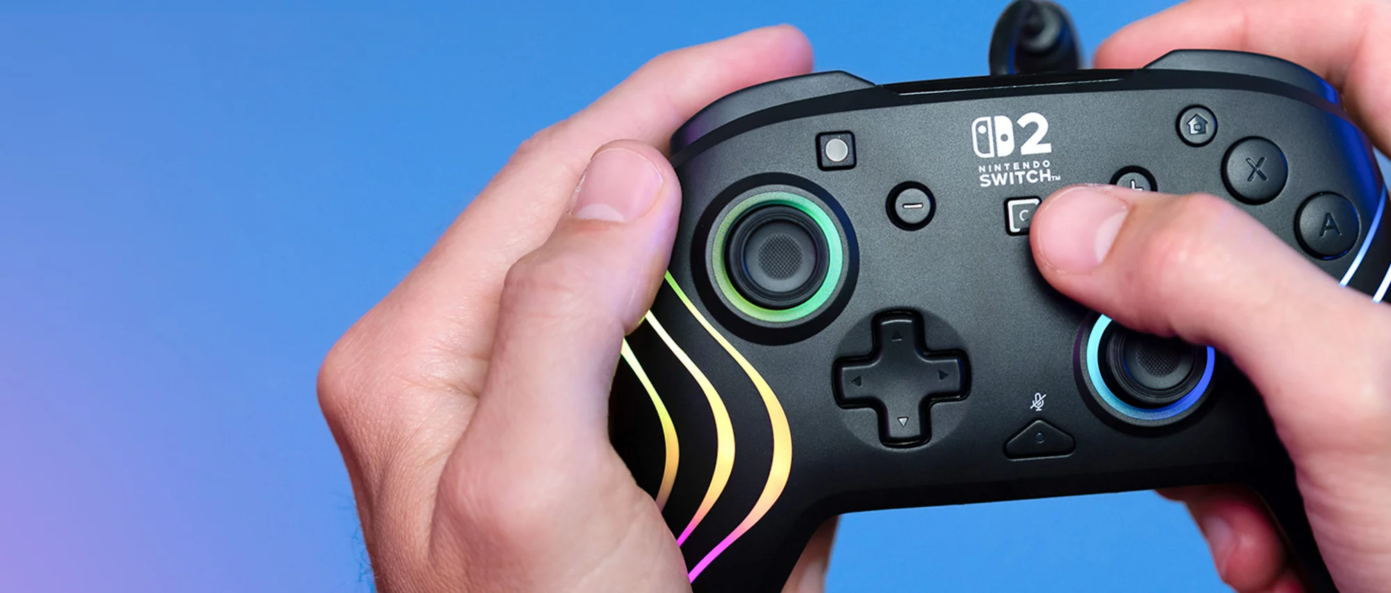Hände halten einen schwarzen Nintendo Switch-Controller. Knöpfe und Joysticks sind sichtbar. Der Hintergrund ist blau.