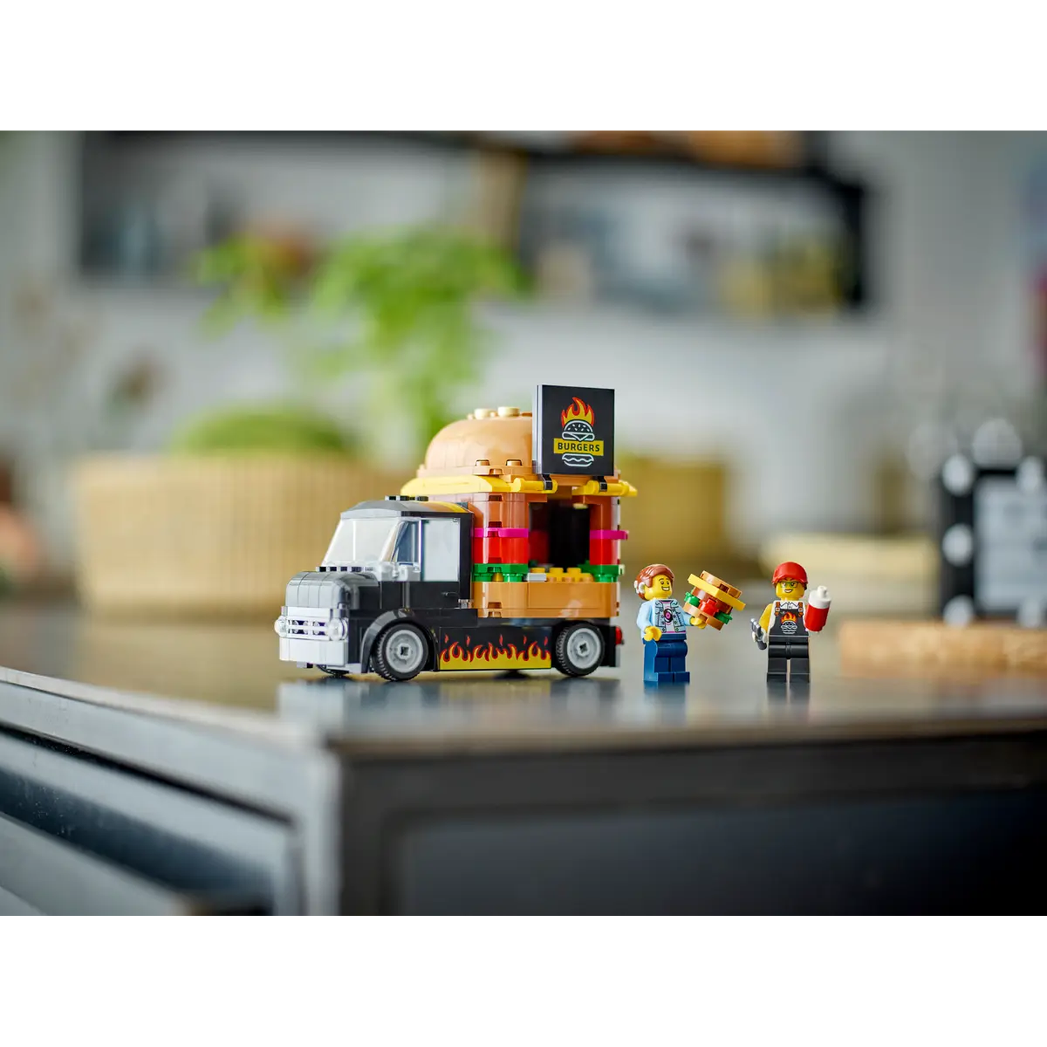 Lego food truck with burger sign. Two Lego figures, one holding a burger, the other a drink. Flames on truck's side.