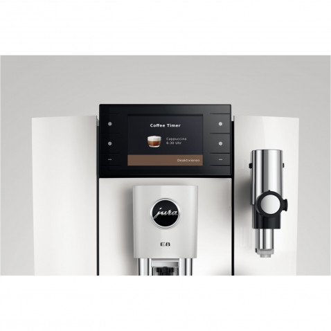 Biało-czarny ekspres do kawy Jura E8. Posiada ekran z ustawieniami cappuccino. Po prawej stronie znajduje się spieniacz do mleka ze stali nierdzewnej.