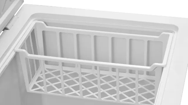 Wewnątrz białej zamrażarki widoczny jest biały kosz. Kosz ma dno w kratkę i prostokątny kształt. Pokrywa zamrażarki jest otwarta.