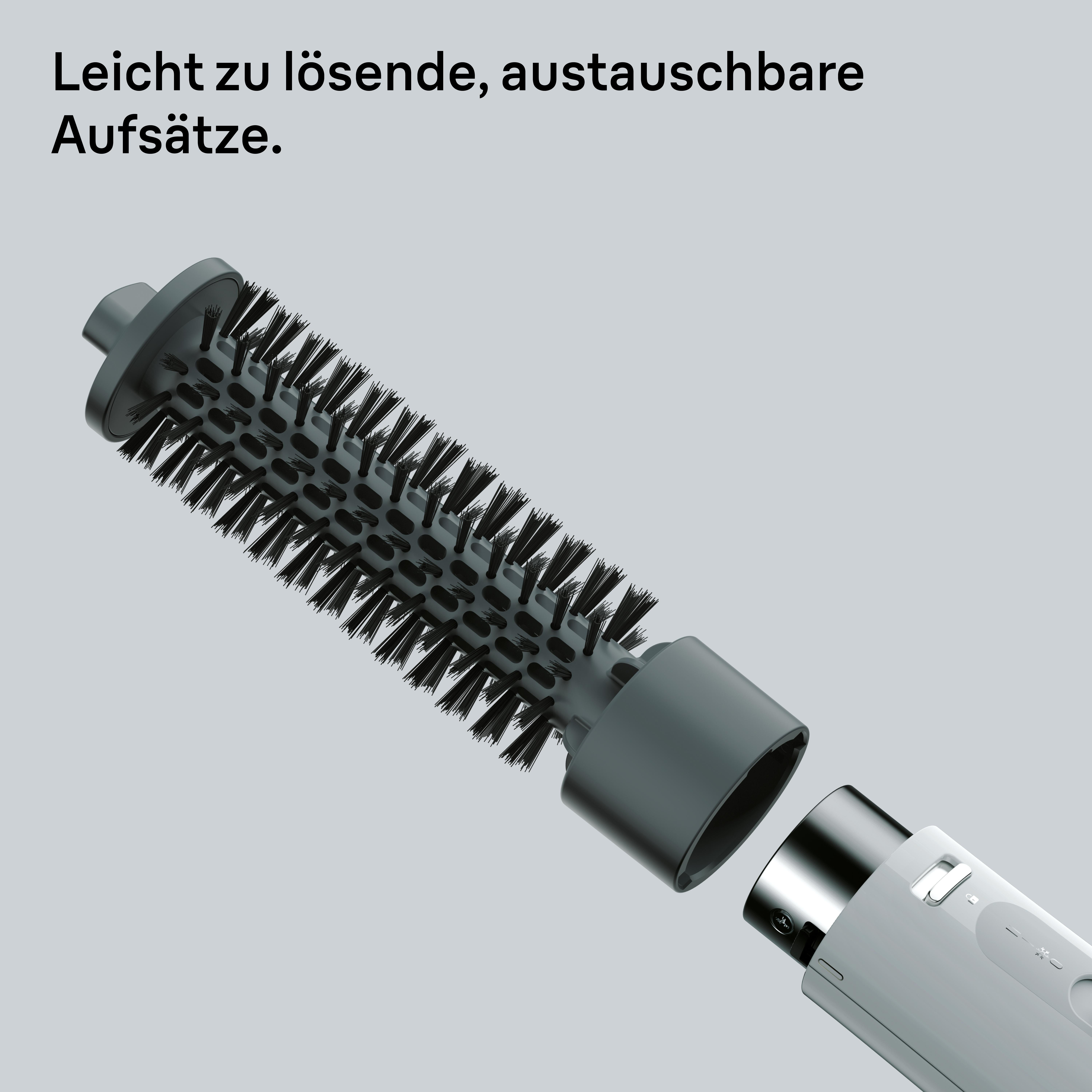 Haarstyling-Werkzeug mit abgenommenem Bürstenaufsatz. Graue Bürste mit schwarzen Borsten. Weißer Griff. Text: Leicht zu lösende Aufsätze.