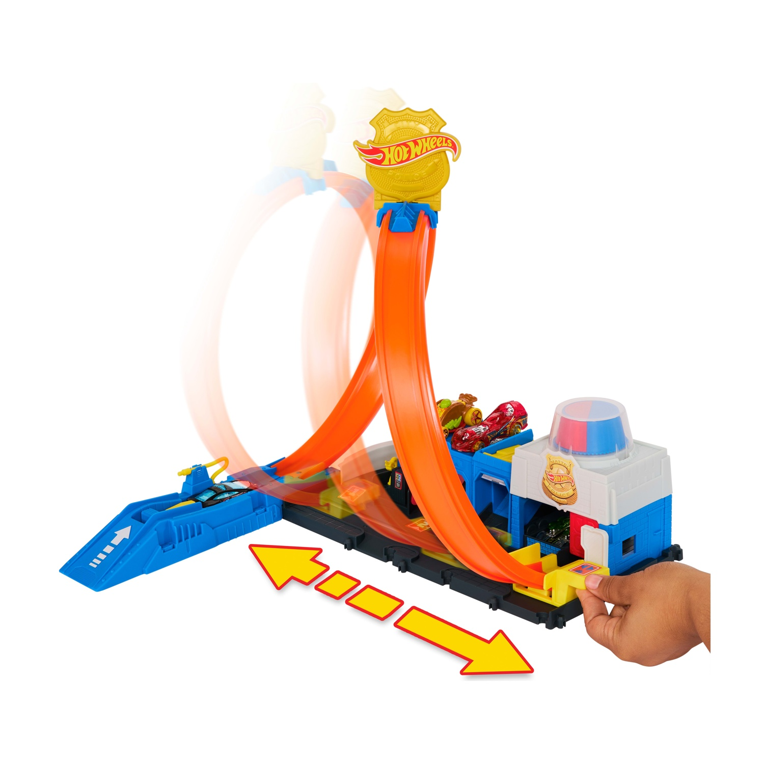 Set pista Hot Wheels con loop, auto e un edificio a tema stazione di polizia. Una mano sta per lanciare le auto.