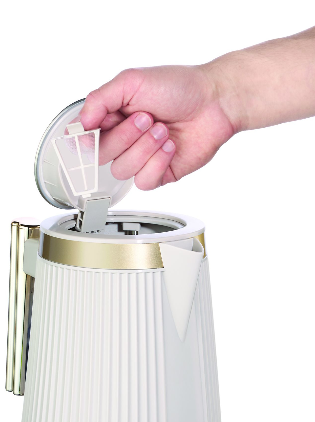 Ręka umieszcza filtr w białym i złotym czajniku elektrycznym. Czajnik ma żebrowaną konstrukcję i znajduje się na białym tle.