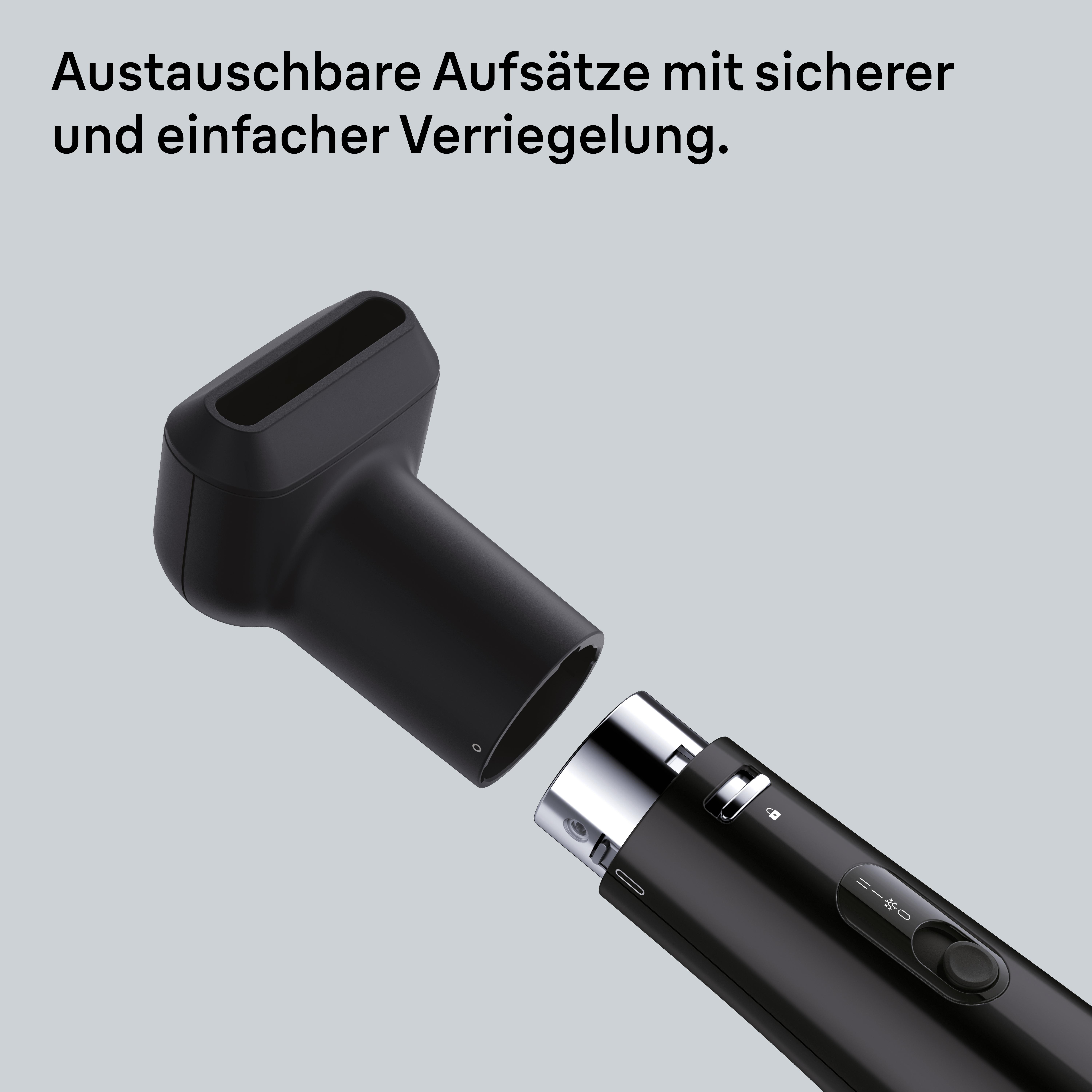 Schwarzer Haartrockner mit abgenommenem Aufsatz, bereit zum Anschließen. Grauer Hintergrund.