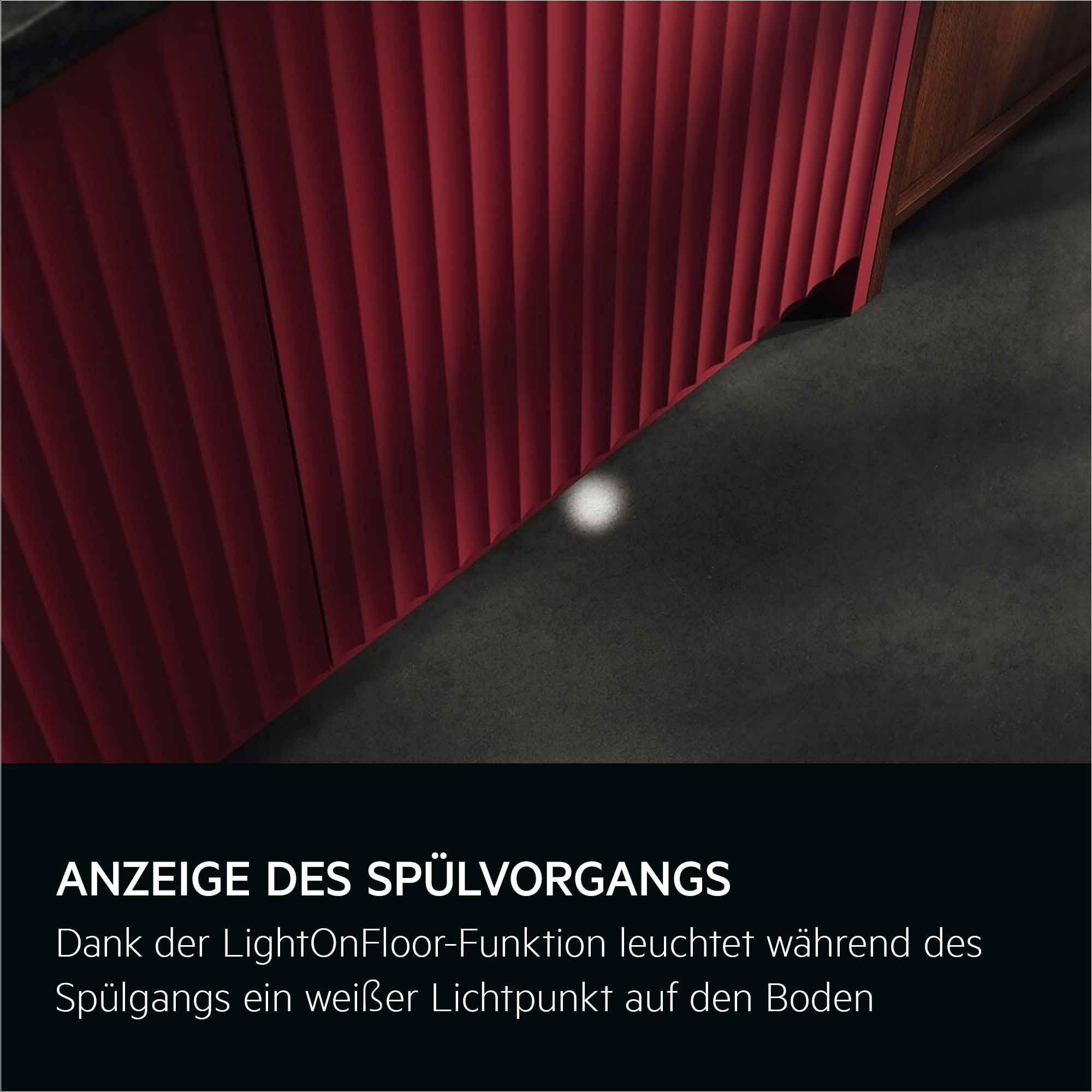 Rote strukturierte Schrankecke. Ein weißer Lichtfleck auf dem dunklen Boden. Text unten.