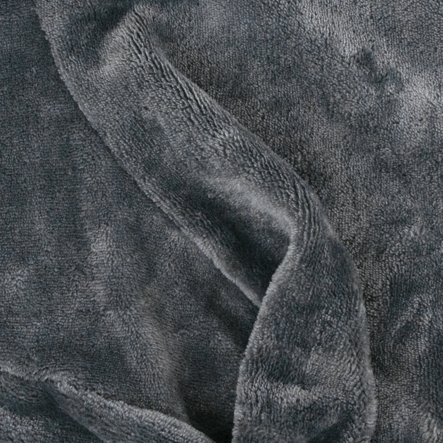 Gros plan sur un tissu gris doux avec des plis et une surface texturée. Le tissu semble moelleux et chaud, suggérant une couverture ou un tissu.