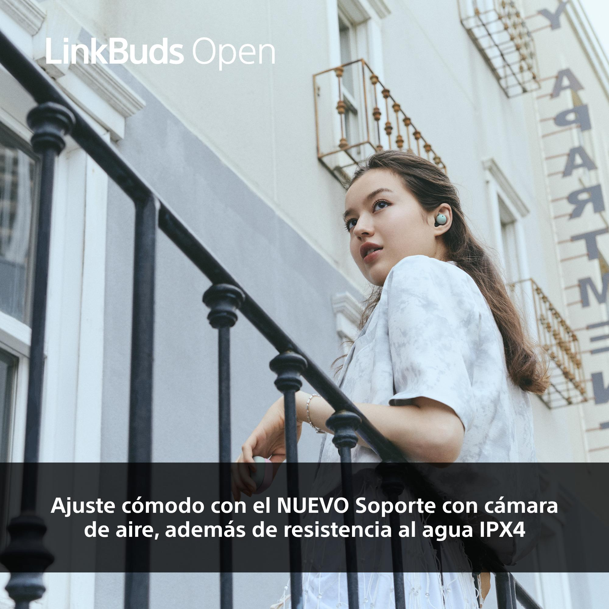 Mujer con auriculares en balcón. Texto 'LinkBuds Open'. Barandilla en balcón. Edificio en el fondo.