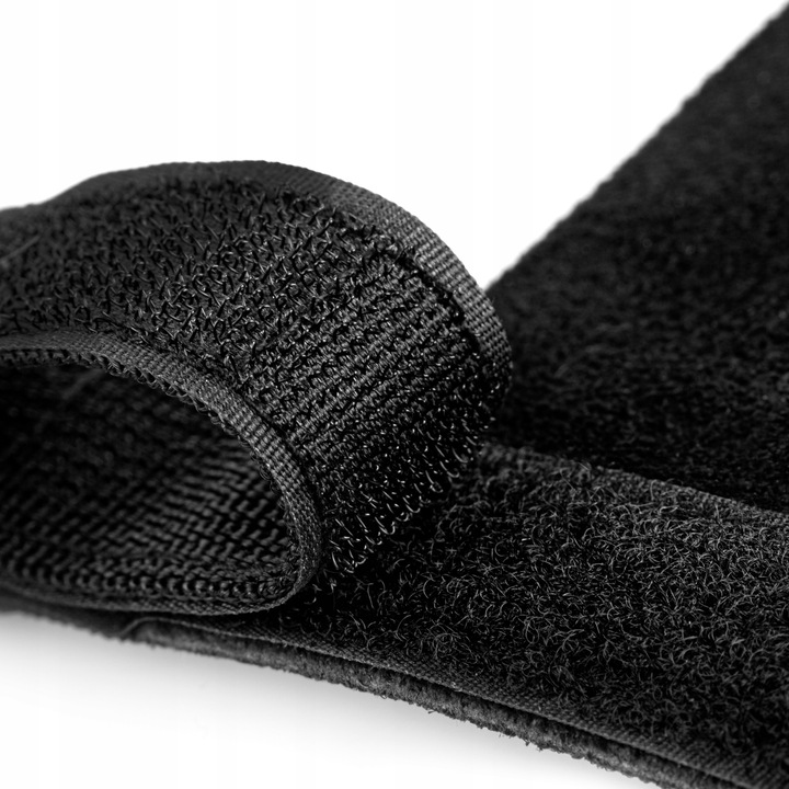 Zbliżenie czarnego paska na rzep. Widoczna strona z haczykami, ze pętelkami i tkaną krawędzią. Tło białe.