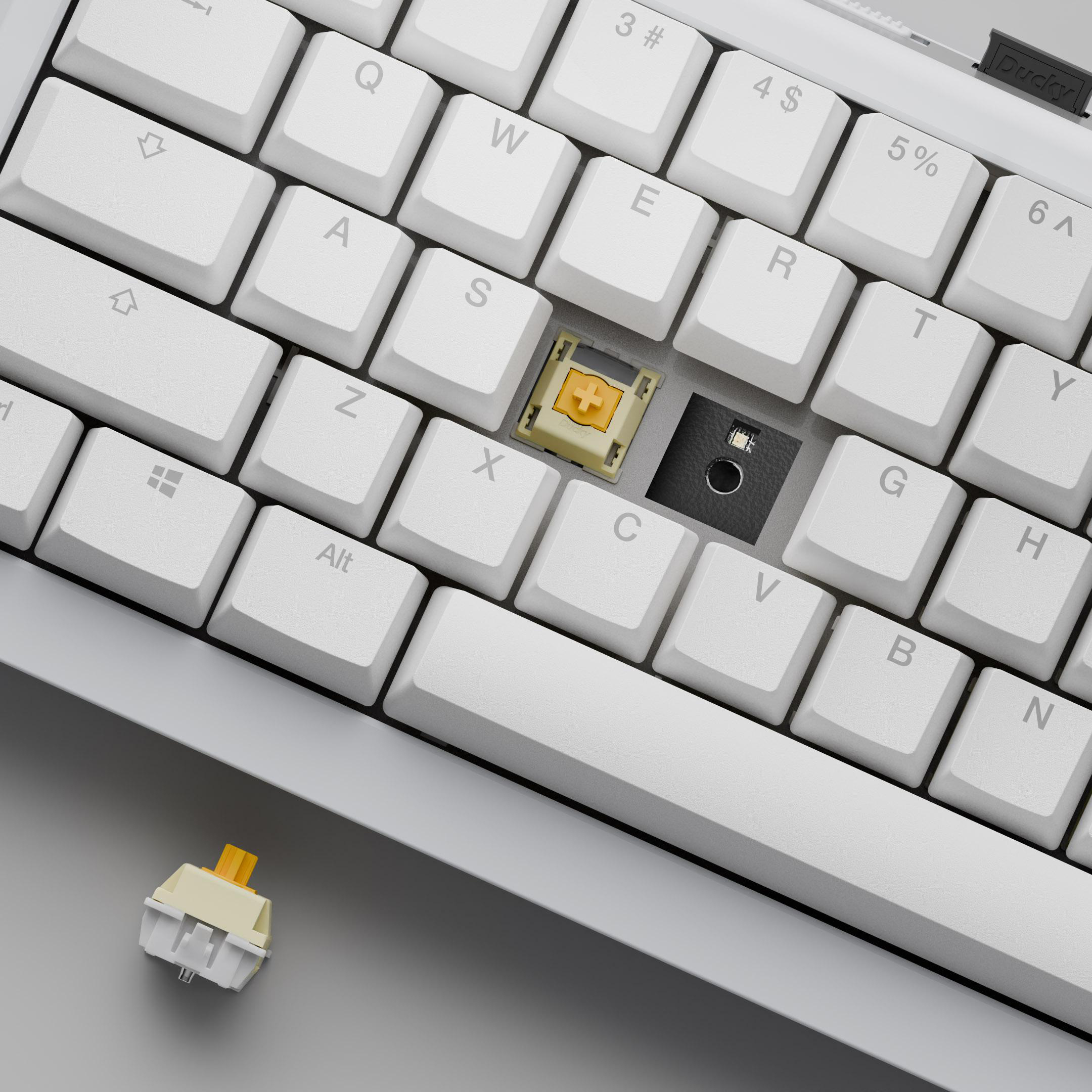 Weiße Tastatur mit entfernten Tastenkappen, die einen Schalter freilegen. Ein Schalter ist abgenommen. Der Hintergrund ist grau.