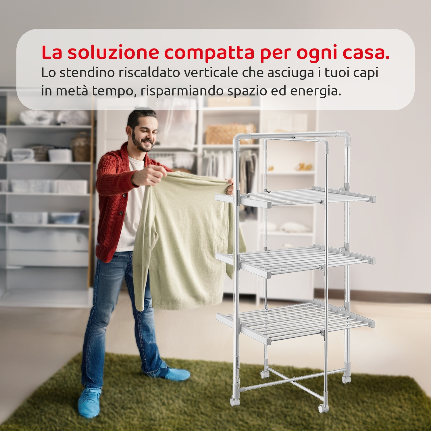 Un uomo tiene un maglione vicino a uno stendino verticale riscaldato. Sotto un tappeto verde. Testo in italiano.
