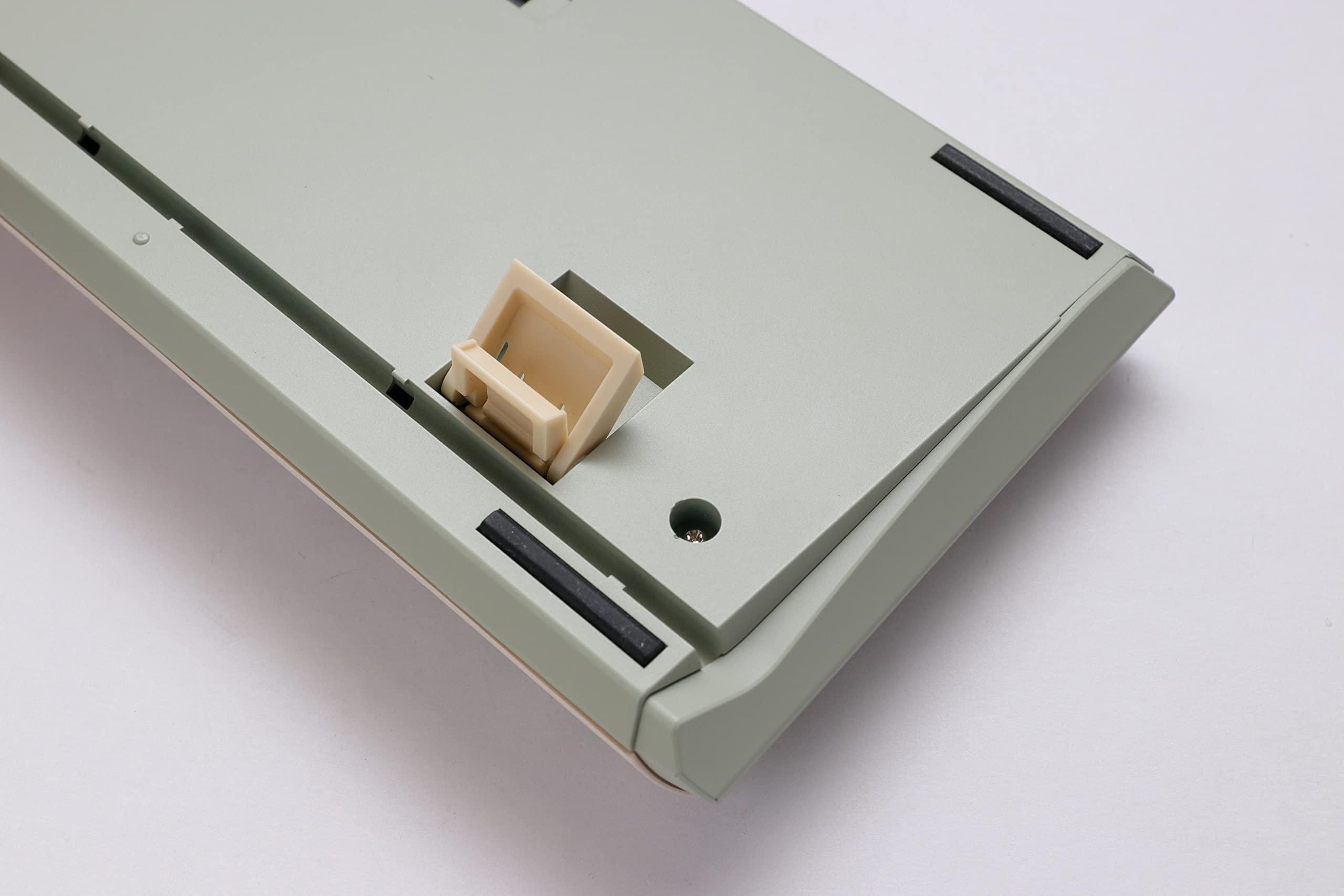 Die Unterseite einer Tastatur wird gezeigt, mit hellgrüner Basis, beigen Akzenten und einem beigefarbenen Kunststoffständer.
