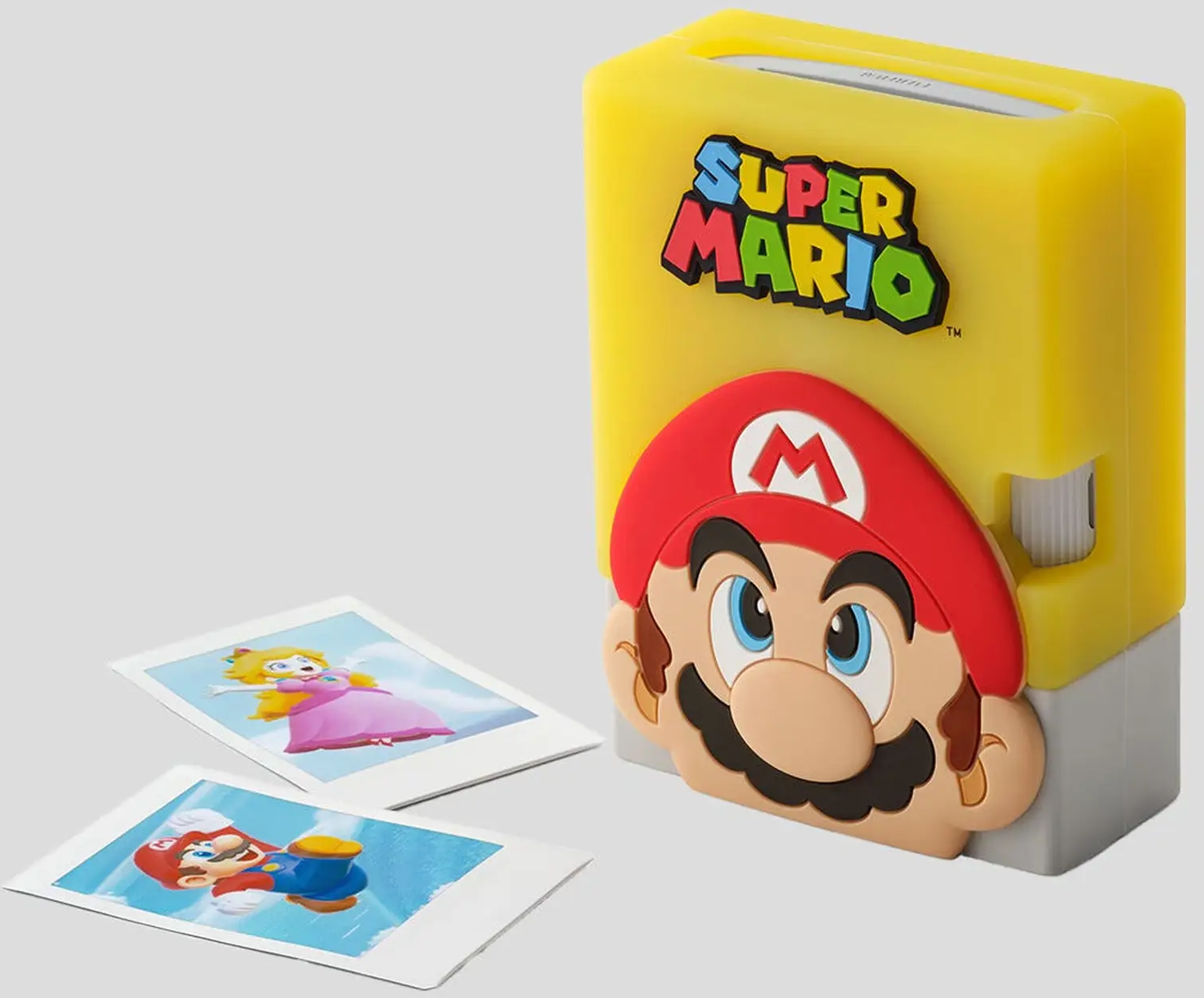 Ein gelber Super Mario Fotodrucker mit Marios Gesicht. Zwei Fotos zeigen Prinzessin Peach und Mario. Weißer Hintergrund.