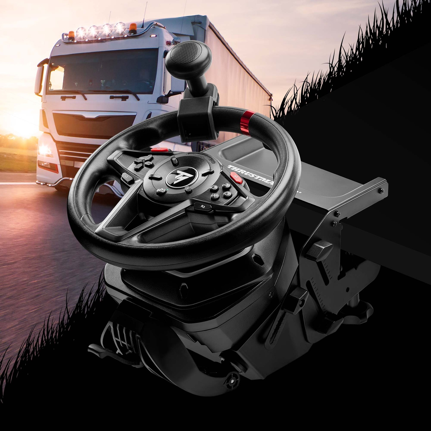 Un volant noir devant un camion. Le camion roule sur une route. Il y a un coucher de soleil en arrière-plan.