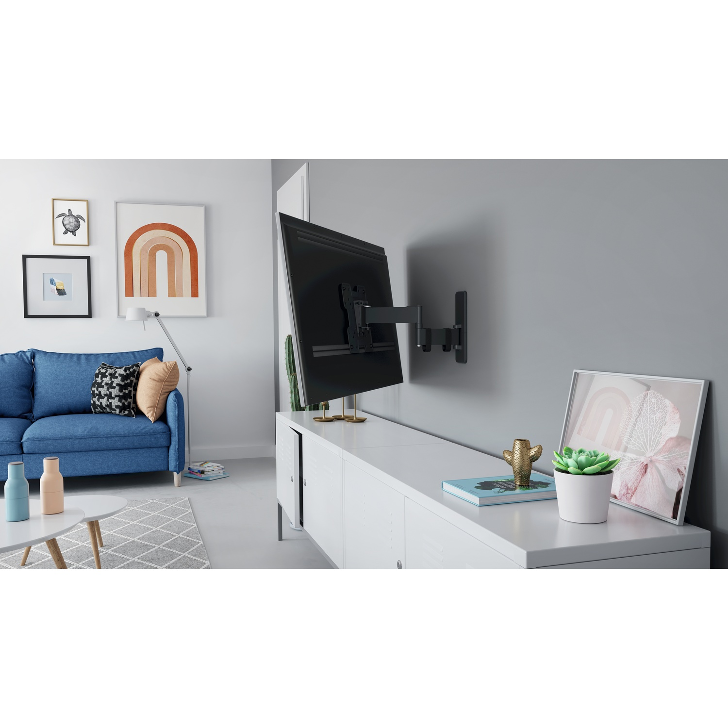 Woonkamer met blauwe bank, witte kast, tv aan de muurbevestiging en ingelijste kunst. Decoratieve items op de kast.