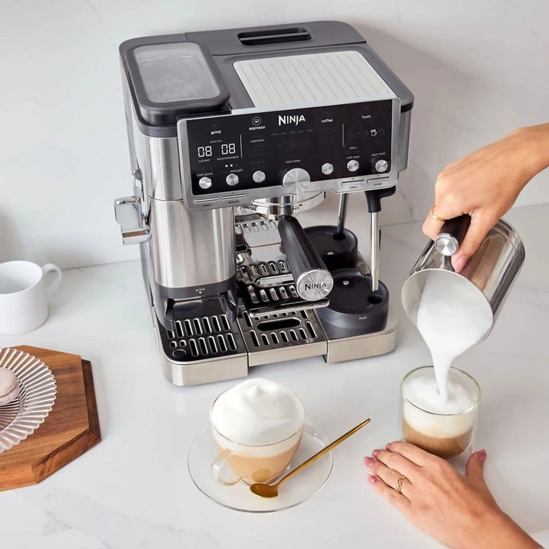 Máquina de espresso Ninja haciendo café. Se vierte espuma en un vaso. Una taza de café con espuma.