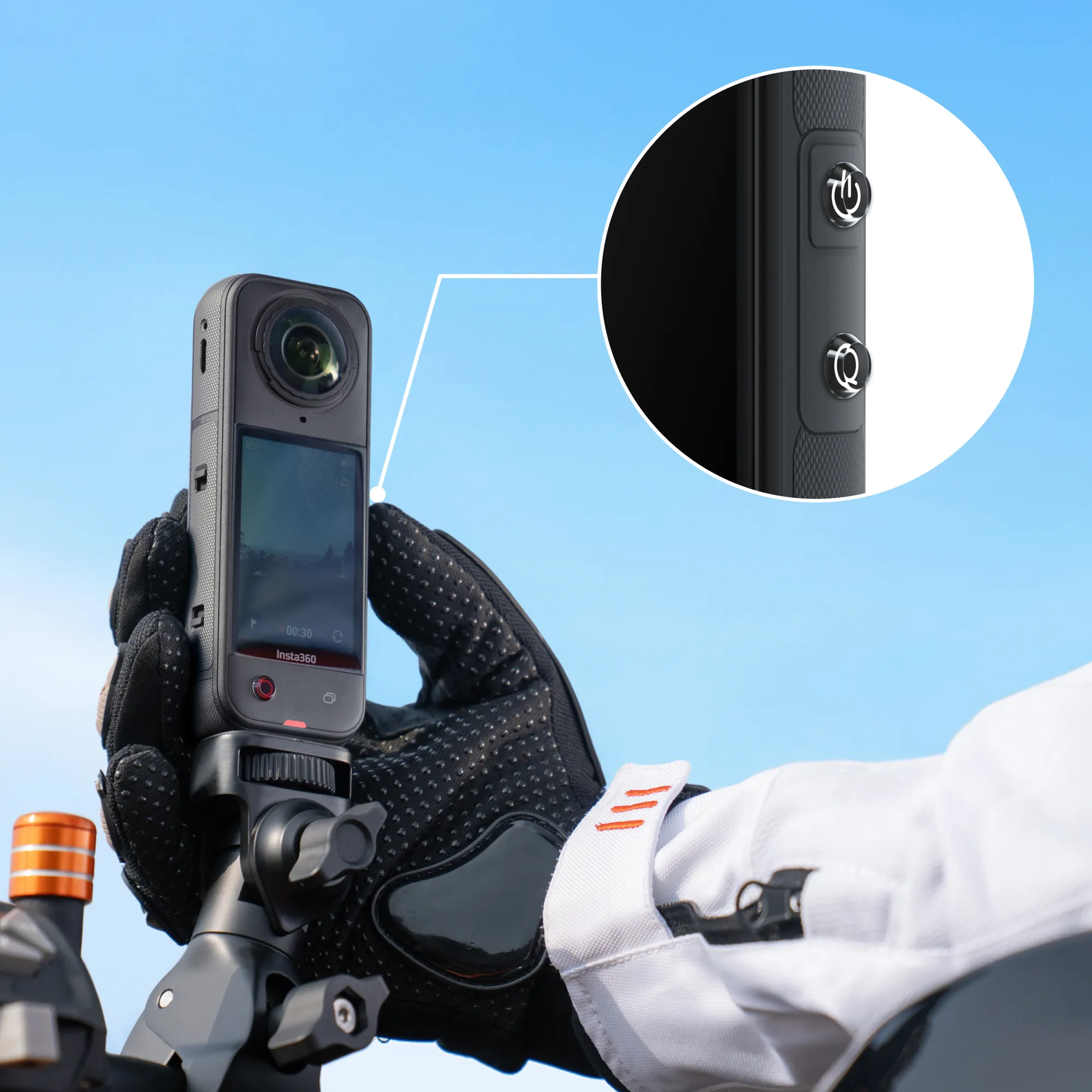 Eine Person hält eine schwarze Insta360-Kamera. Die Kamera zeigt ein Video. Blauer Himmel im Hintergrund.