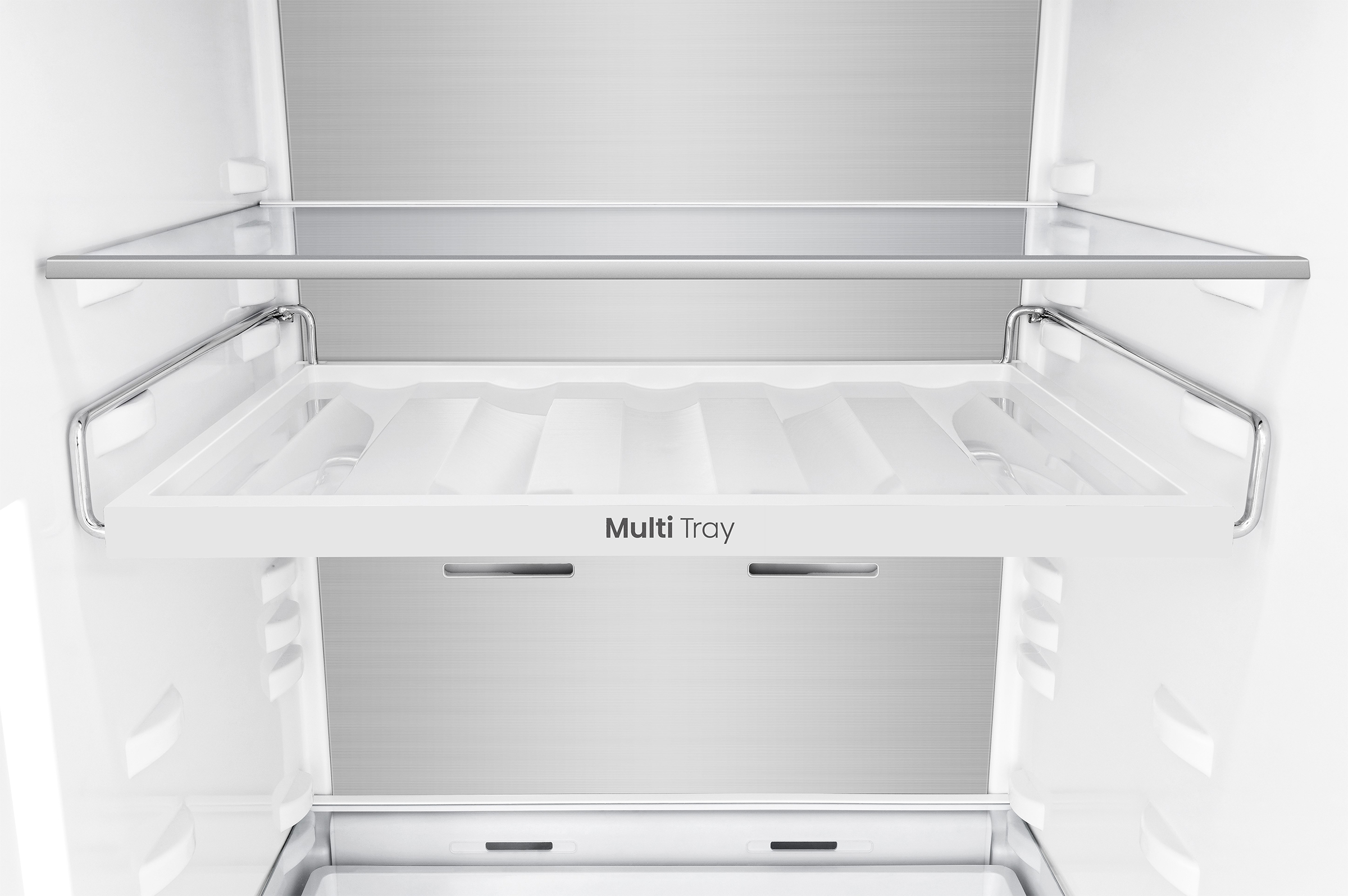 Binnenkant van een koelkast, met planken en trays. Witte binnenkant met metalen achterpaneel en de tekst 'Multi Tray'.