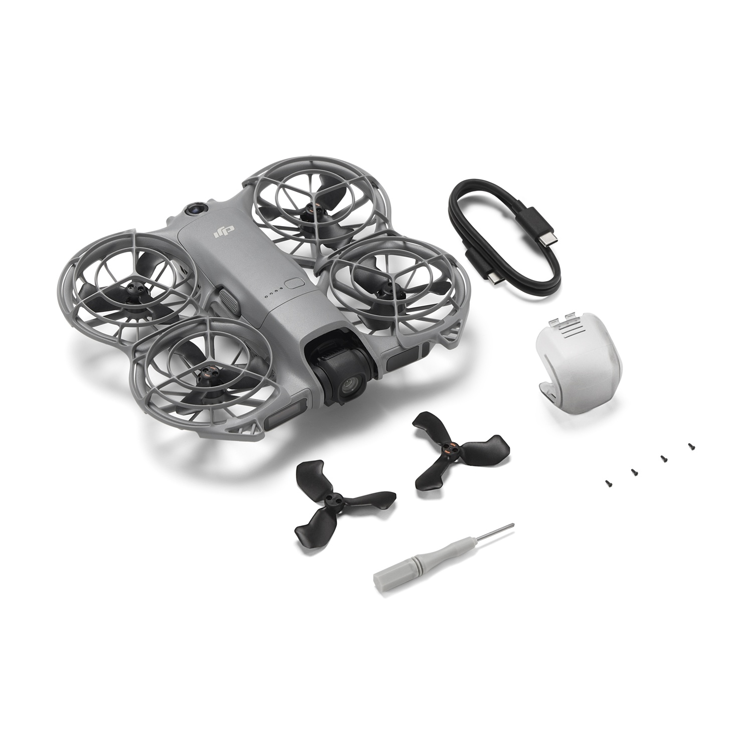 Un drone grigio con eliche è mostrato, insieme a un cavo nero, eliche di ricambio, un cacciavite e viti, il tutto su una superficie bianca.