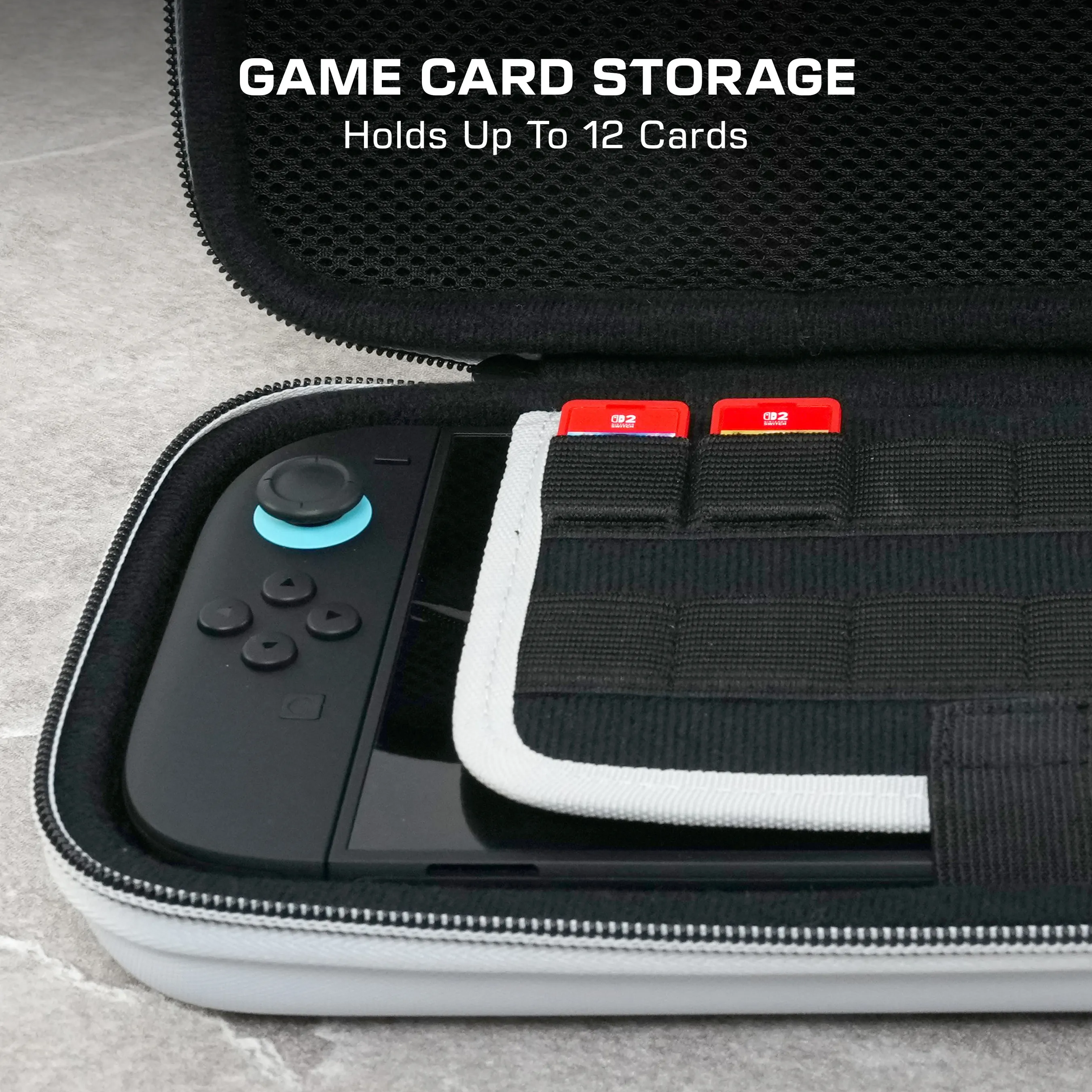 Étui de rangement de cartes de jeu ouvert avec Switch et cartes de jeu. Étui noir et blanc. Deux cartes de jeu rouges sont visibles.