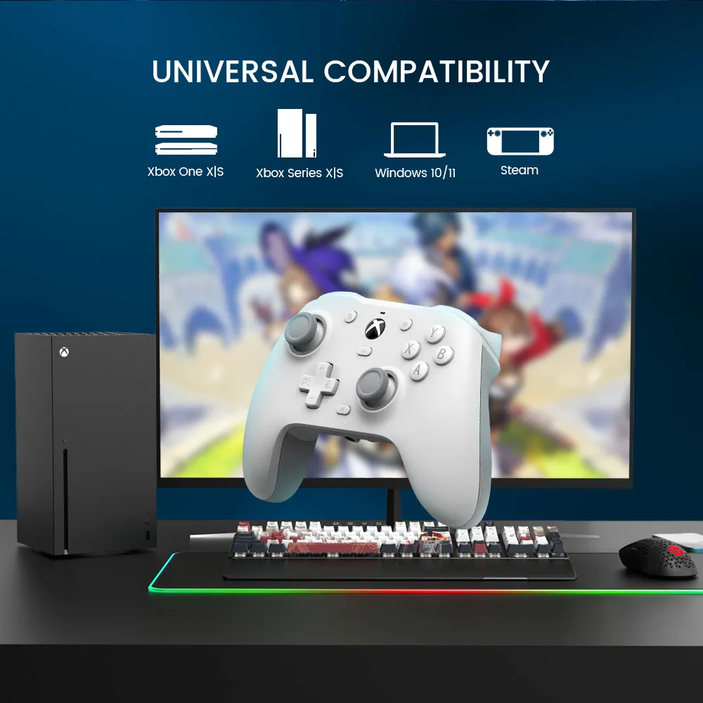 Das Bild zeigt ein Gaming-Setup mit Xbox-Konsole, weißem Controller, Tastatur, Maus und Monitor, Steam- und Xbox-Kompatibilitätssymbolen.