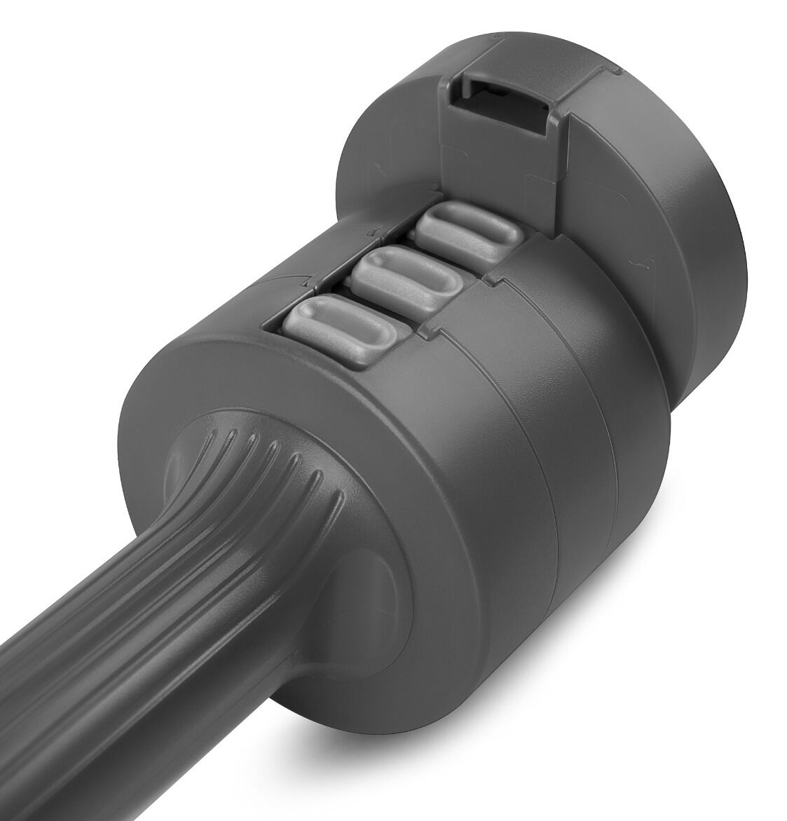 Zbliżenie szarego elementu odkurzacza. Ma trzy owalne przyciski i cylindryczny korpus z uchwytem rozciągającym się w lewo.