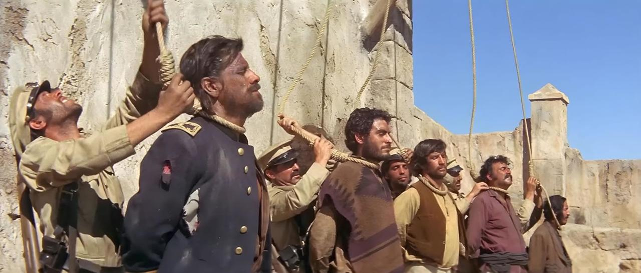Männer werden gehängt. Soldaten in Uniform halten Seile um den Hals von Männern. Im Hintergrund eine Steinmauer.